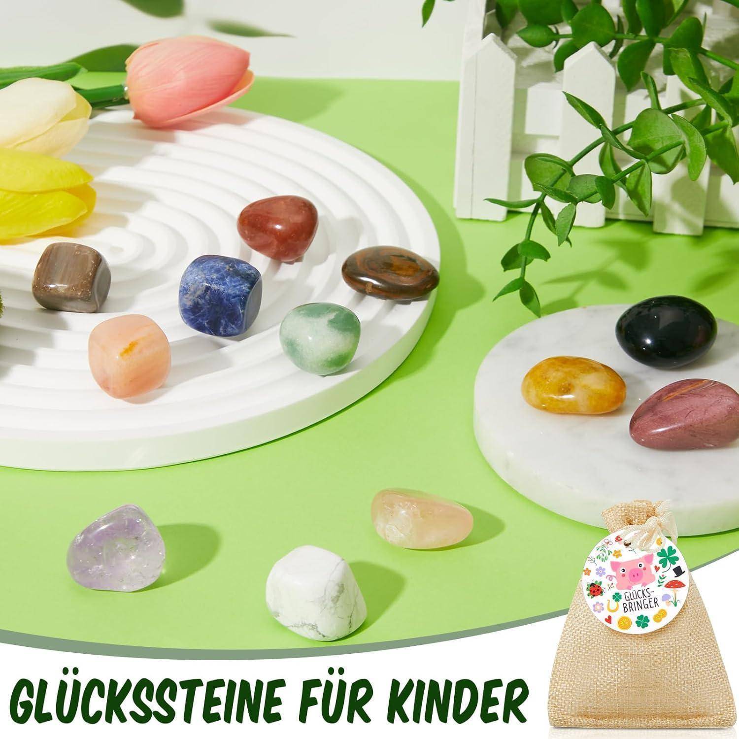 Verschiedenfarbige Steine sind auf weißen Tabletts angeordnet, mit einer Tasche, die mit 