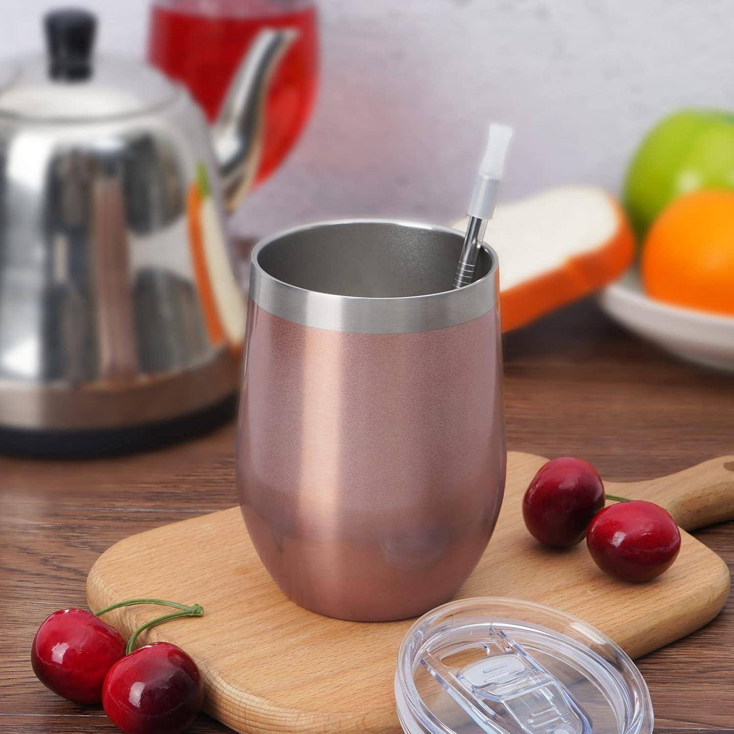 Eine Kupfertasse mit Deckel und Strohhalm auf einem Holzbrett, umgeben von Kirschen. Eine Teekanne und ein Obsttellerchen sind im Hintergrund unscharf.