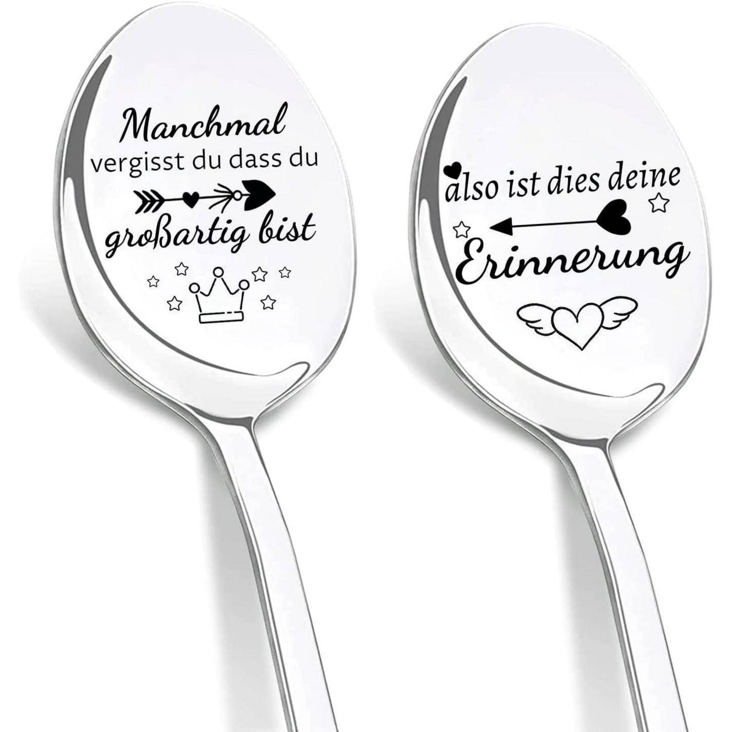 Zwei Silberlöffel mit deutschen Phrasen. Links: 'Manchmal vergisst du, dass du großartig bist' mit einer Krone. Rechts: 'Also ist dies deine Erinnerung' mit einem Herz und Pfeil.
