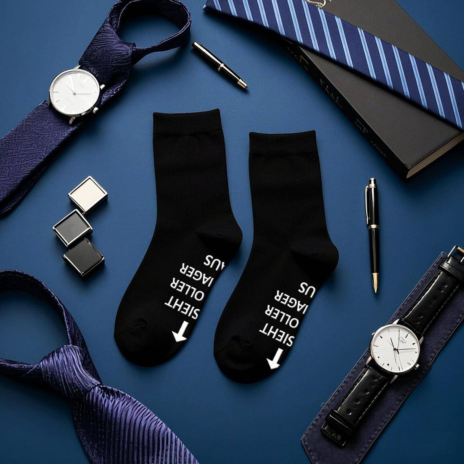 Flatlay von Männer-Accessoires: Armbanduhren, gestreifte Krawatte, Manschettenknöpfe, Stift und schwarze Socken mit den Beschriftungen „LINKS