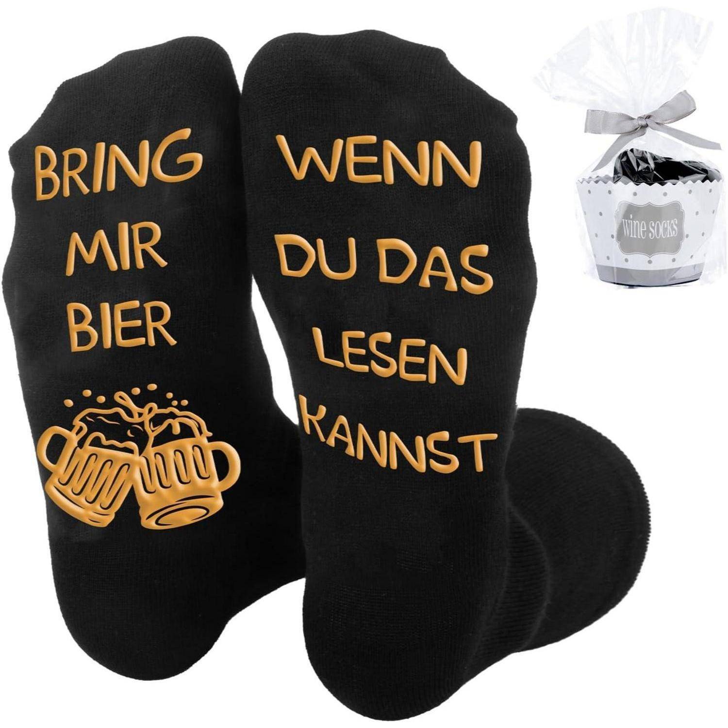 Schwarze Socken mit goldener Schrift. Der linke Socken trägt die Aufschrift 'BRING MIR BIER' mit zusammenstoßenden Bierkrügen. Der rechte Socken trägt die Aufschrift 'WENN DU DAS LESEN KANNST'.