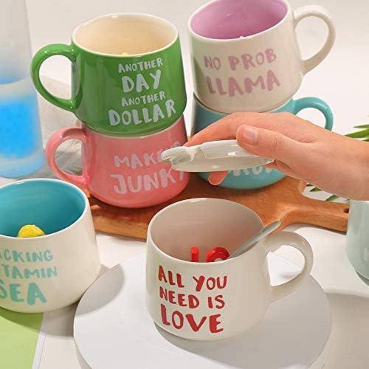 Eine Hand hält einen Deckel über eine Tasse mit dem Aufdruck 