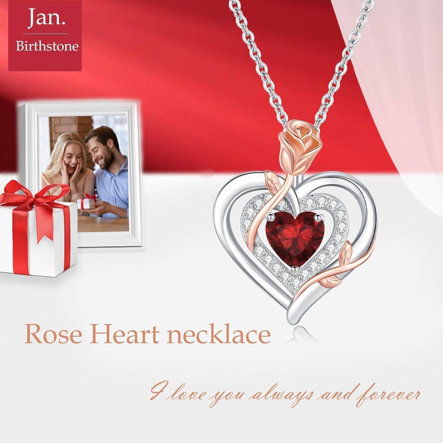 Eine Geschenkbox, ein sitzendes Paar und eine Rosenherz-Halskette mit rotem Edelstein. Text: 'Jan. Geburtsstein' und 'Rosenherz-Halskette - Ich liebe dich immer und für immer.