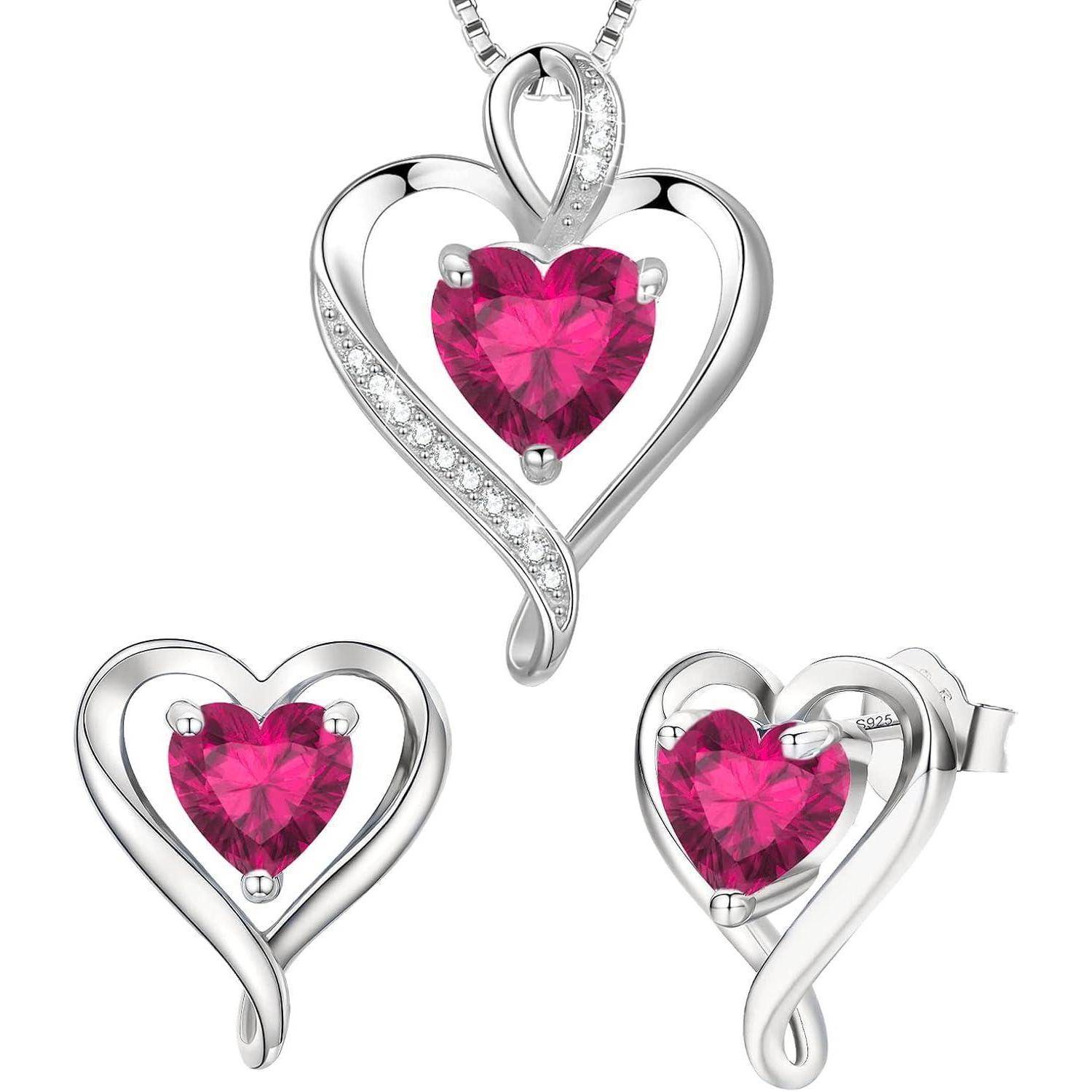 Ein silbernes, herzförmiges Schmuckset aus Halskette und Ohrringe zeigt auffällige rosa Herzen aus Edelsteinen in der Mitte, geschmückt mit kleinen Kristallen.