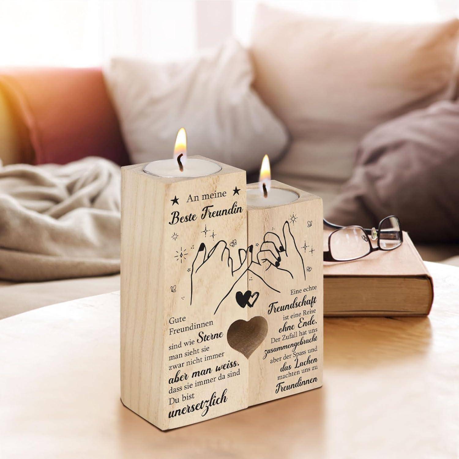Ein hölzerner Kerzenhalter mit Flammen und gravierten Texten drückt Freundschaftsempfindungen auf Deutsch aus. Daneben ruhen ein Buch und eine Brille auf einem Tisch.