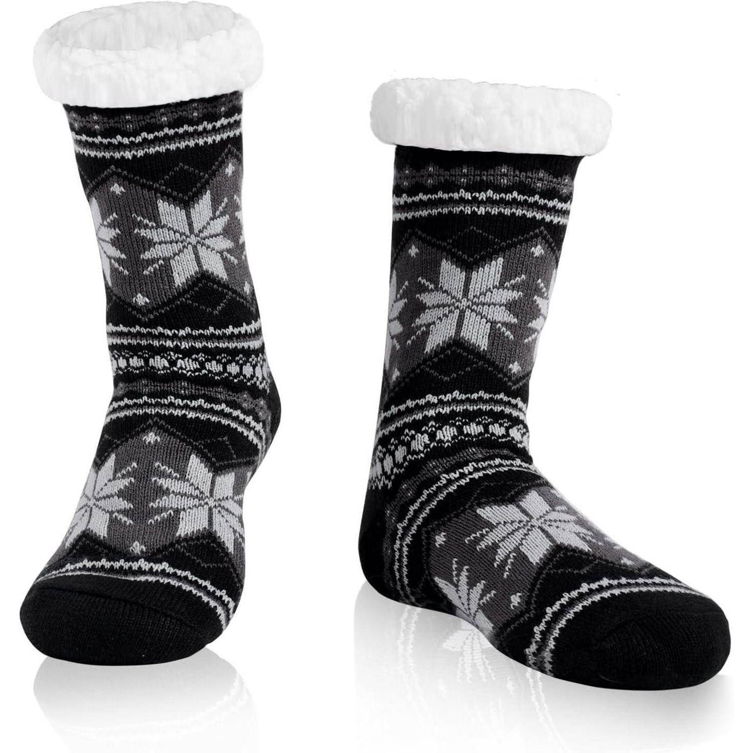 Zwei schwarze Socken mit weißen Schneeflockenmustern und flauschigen weißen Bündchen, die für Wärme und Komfort im Winter konzipiert sind.