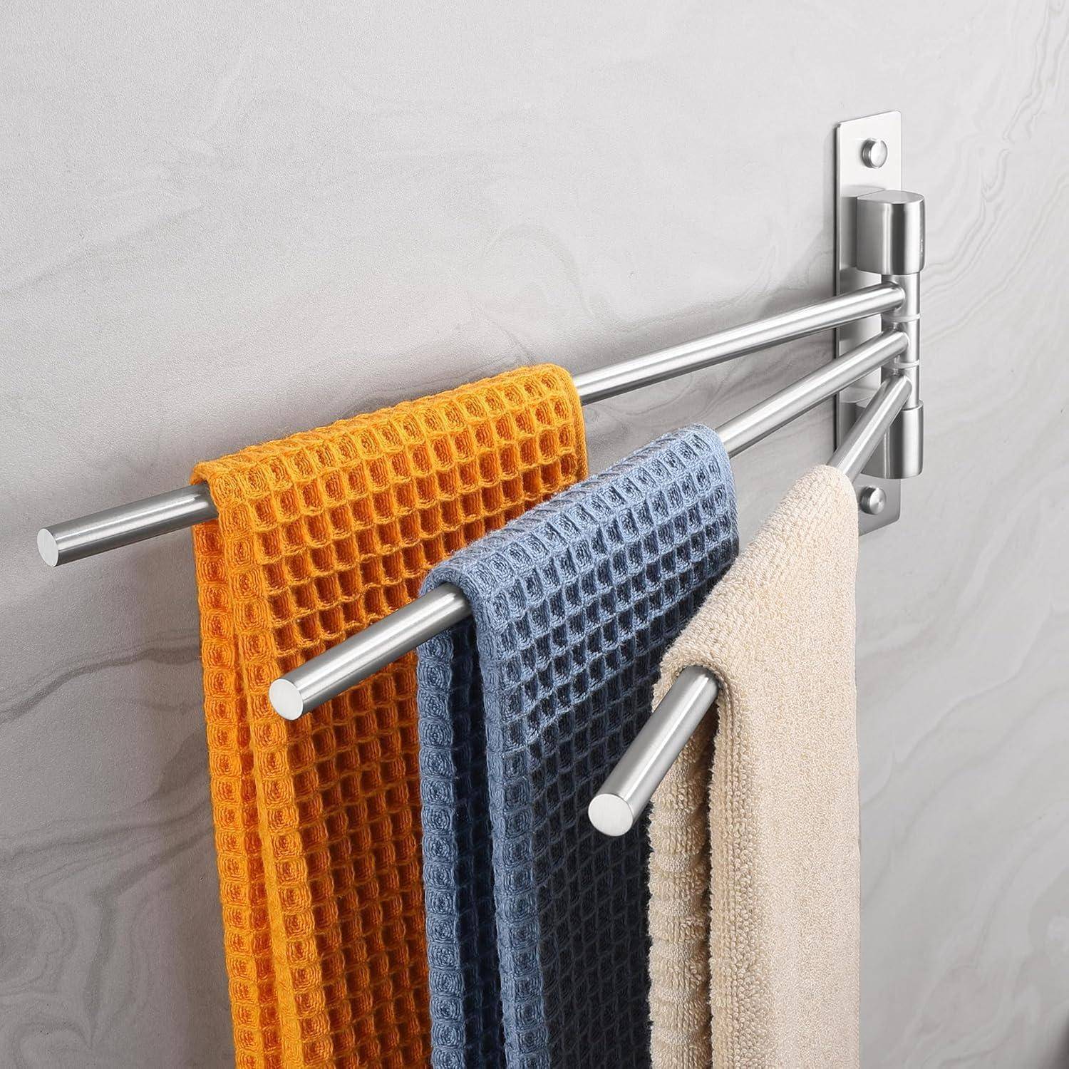 Drei farbenfrohe Handtücher — in Orange, Blau und Beige — hängen ordentlich an einem silbernen, wandmontierten Handtuchhalter mit ausziehbaren Armen, vor einer hellen Wand.