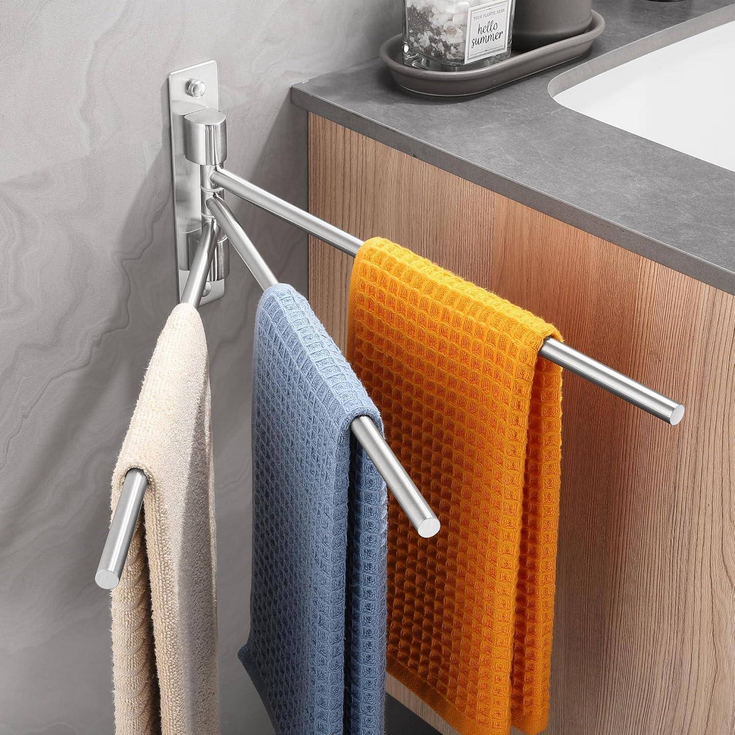 Ein modernes Handtuchhalter an der Badezimmerwand hält drei Handtücher: beige, blau und orange. Der Halter befindet sich neben einer Holz- und Marmorarbeitsfläche.