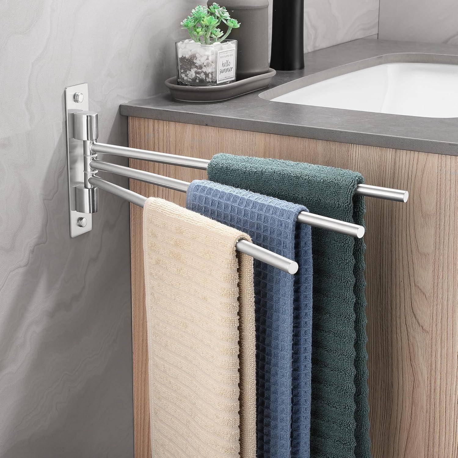 Ein modernes Badezimmer verfügt über eine ausziehbare Handtuchstange mit beigen, blauen und grünen Handtüchern, die neben einem Holzwaschtisch mit einer kleinen Pflanze platziert ist.
