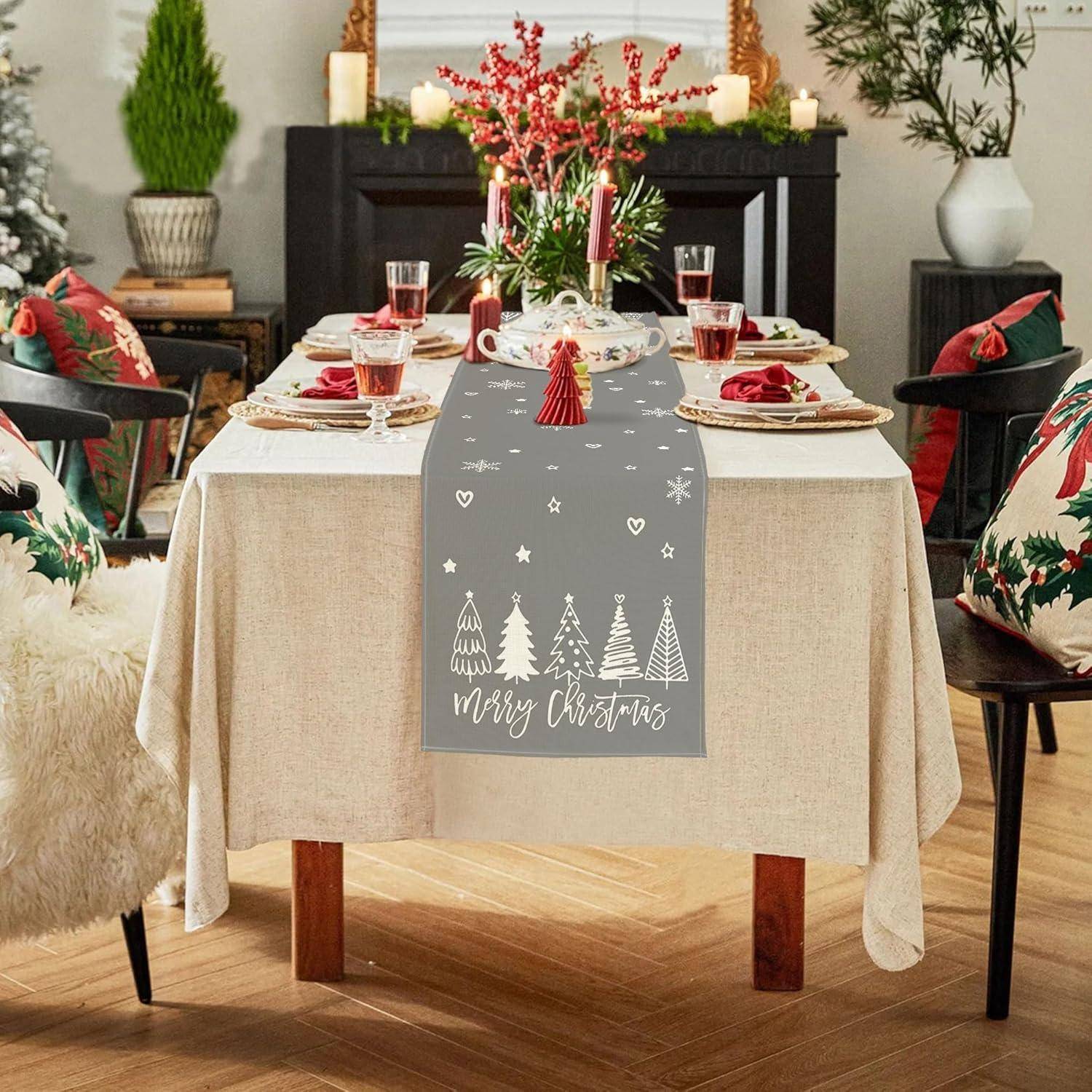 Festlich gedeckter Esstisch für Weihnachten mit einer beigen Tischdecke, grauem Läufer mit der Aufschrift 