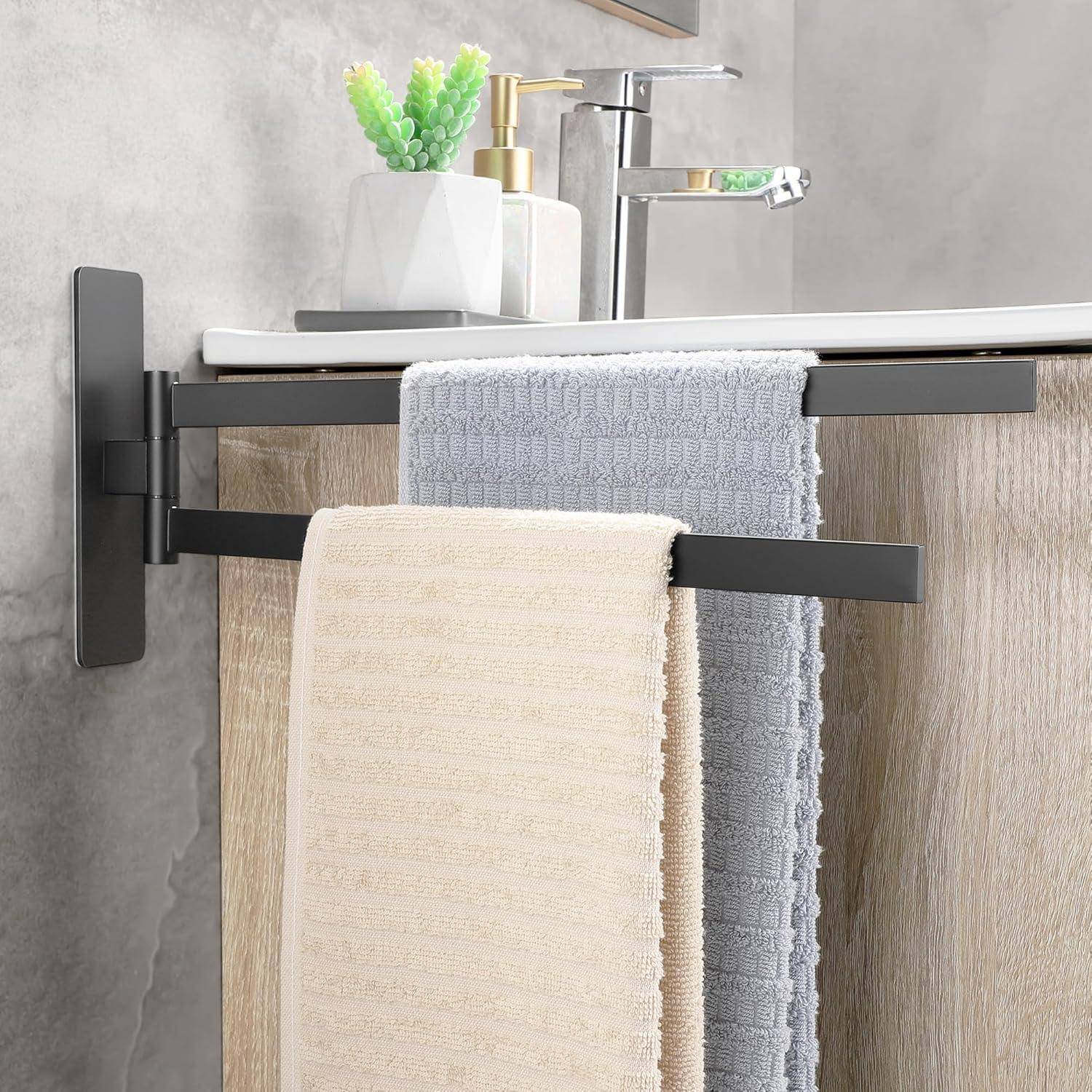 Ein modernes Badezimmer zeigt einen Handtuchhalter mit beigen und grauen Handtüchern neben einem Waschbecken. Ein Seifenspender und eine Pflanze stehen auf der Ablage.