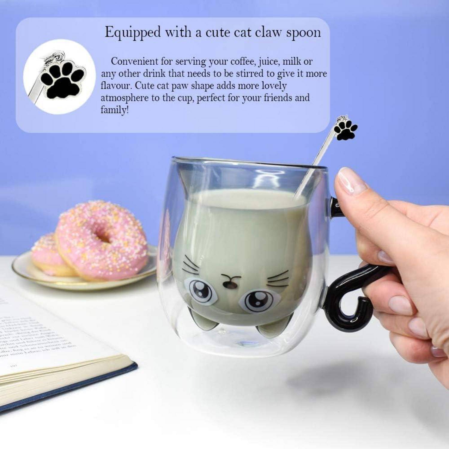 Eine süße katzenthematische Tasse mit einem Katzenklauenlöffel. Die Tasse ist aus Glas mit einem Katzengesicht und wird zum Servieren von Getränken verwendet. Im Hintergrund befinden sich rosa Donuts.
