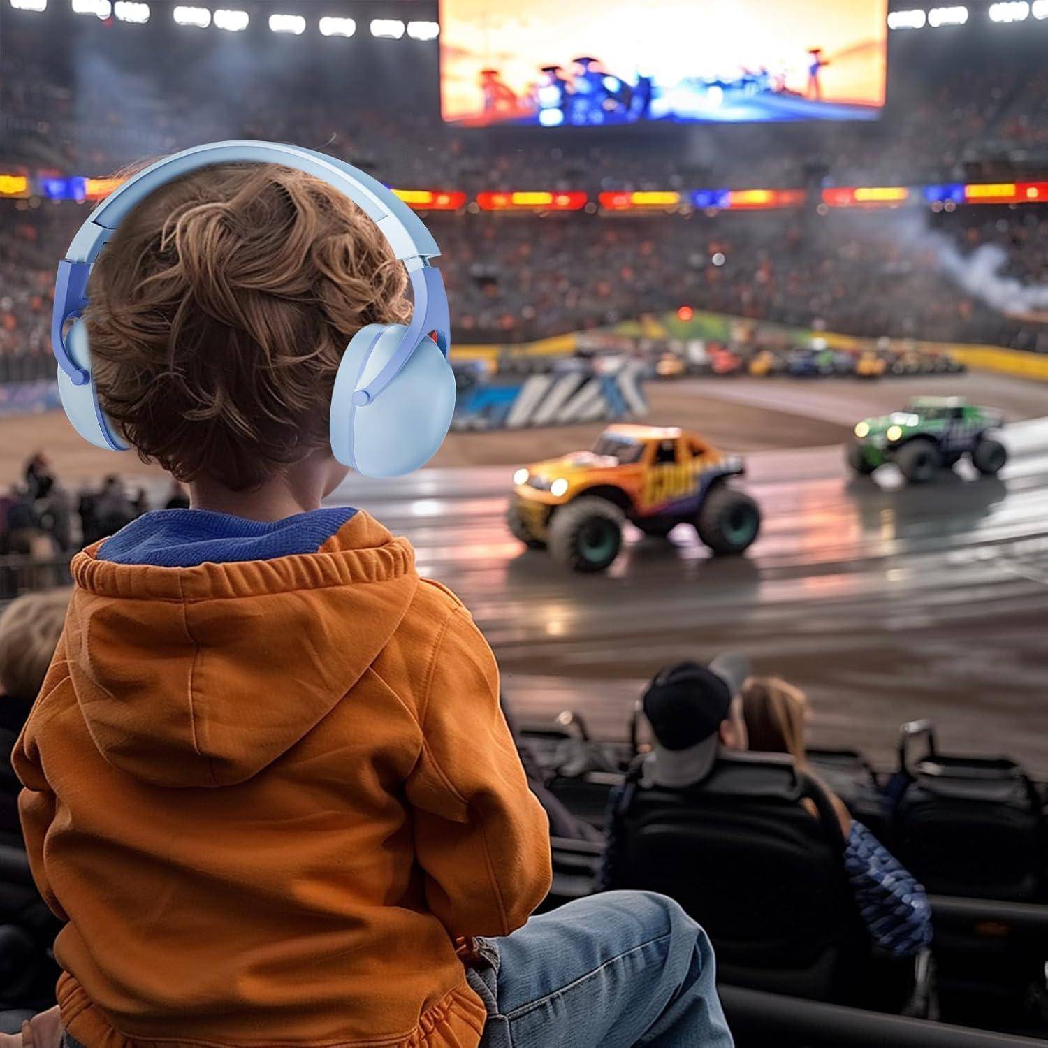 Ein Kind in einem Stadion beobachtet eine Monster-Truck-Show und trägt blaue Kopfhörer zum Gehörschutz. Helle Arenalichter und Trucks sind zu sehen.