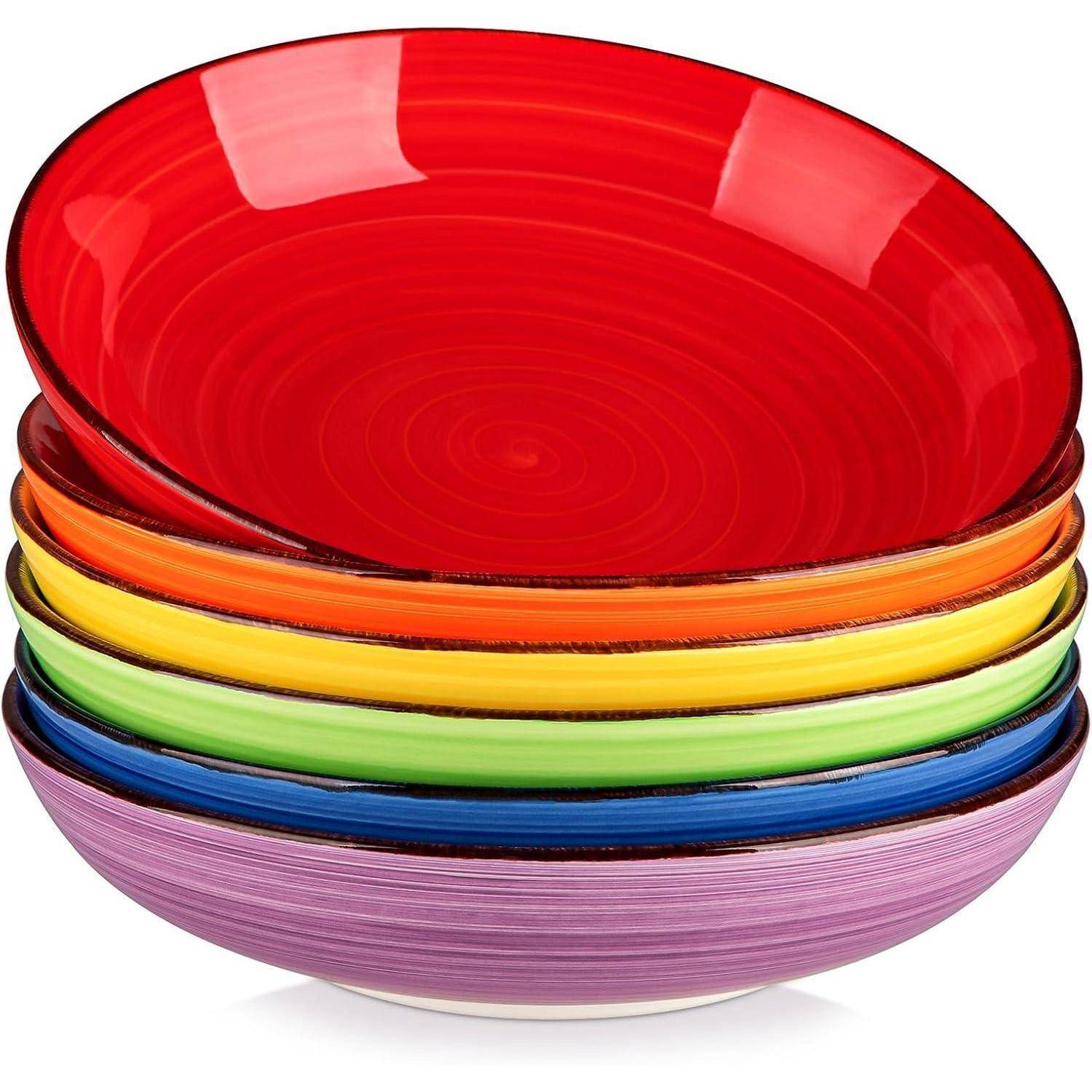 Ein Stapel bunter Keramikschüsseln, jede in einer anderen Farbe des Regenbogens, darunter Rot, Orange, Gelb, Grün, Blau und Violett.