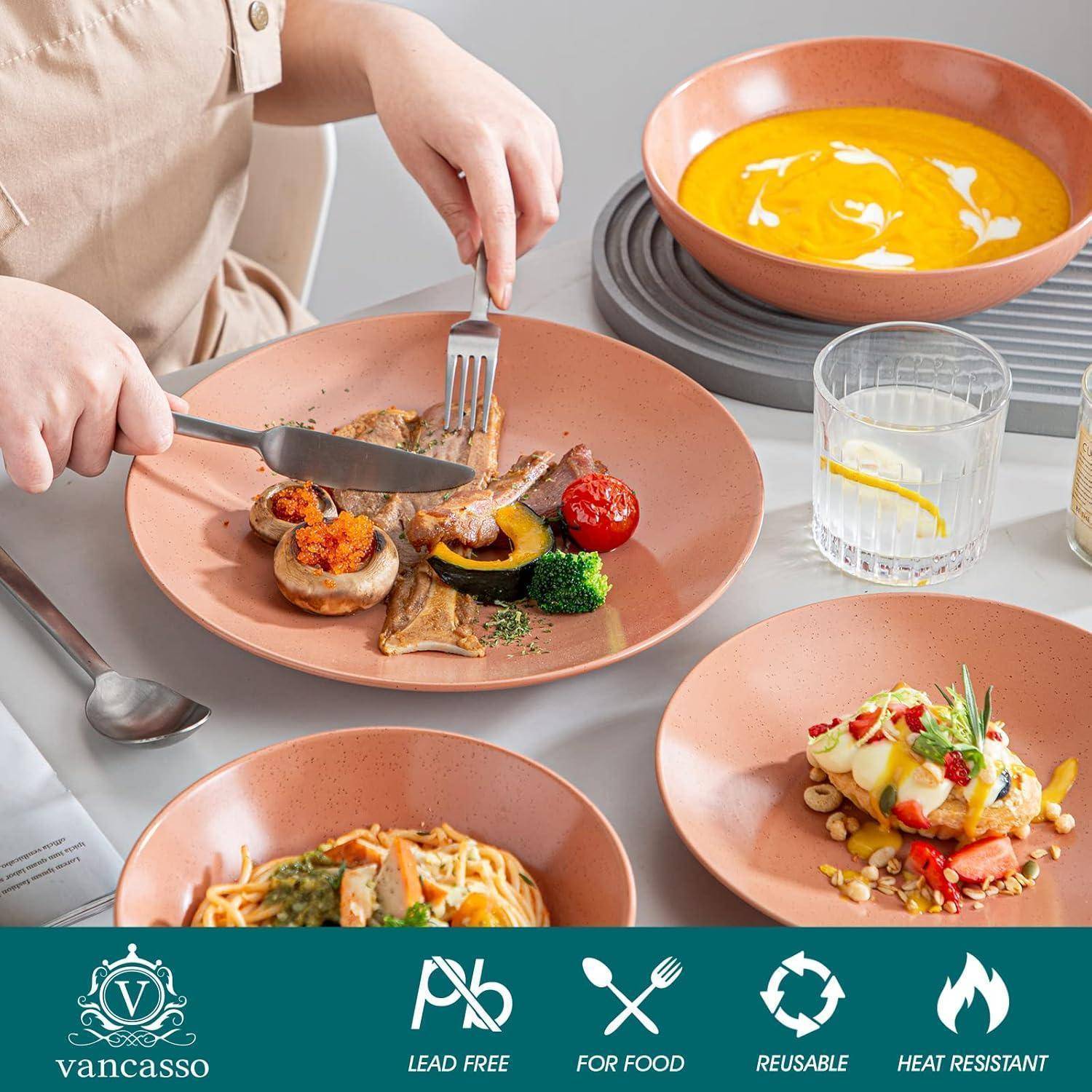 Eine Person, die eine Mahlzeit mit verschiedenen Gerichten genießt, darunter Fleisch, Gemüse und Pasta, serviert auf orangefarbenen Tellern. Dekorative Logos sind auf dem Tischdecken zu sehen.