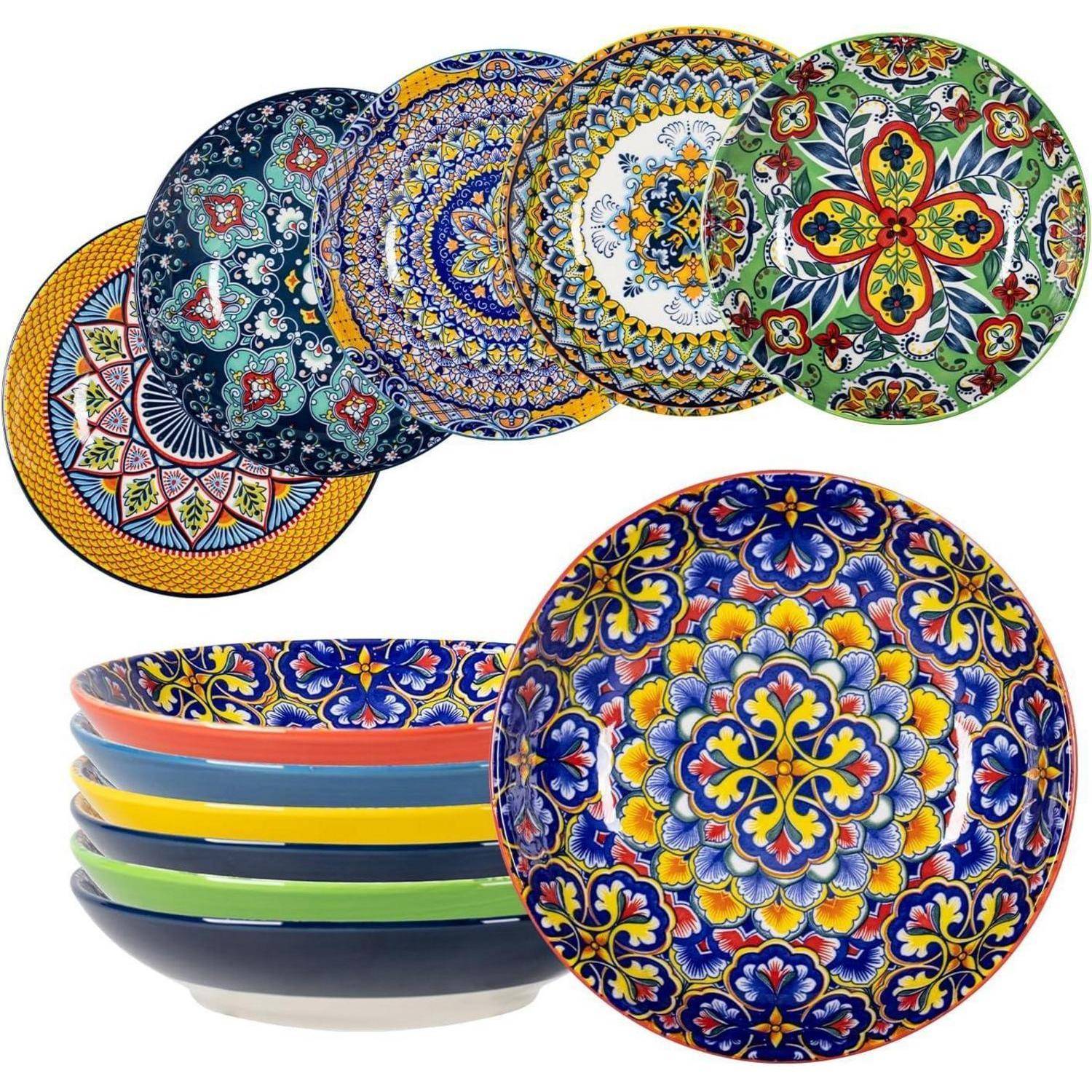 Eine Auswahl an bunten, kunstvoll gemusterten Tellern und Schalen, die übereinander gestapelt sind und dabei komplexe Designs und lebendige Farben präsentieren.