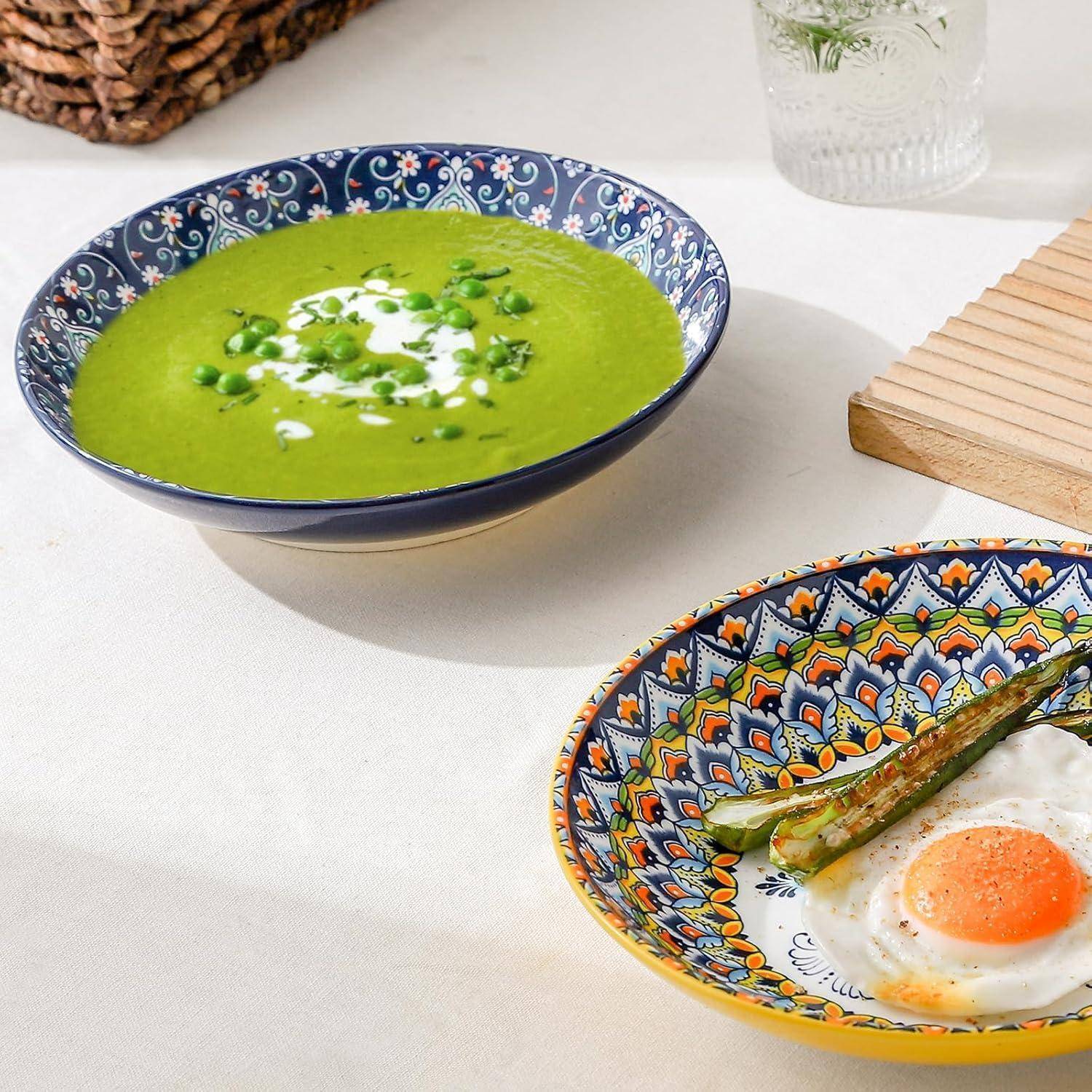 Ein bunter Teller mit einem Spiegelei und grünen Bohnen neben einer Schüssel Erbsensuppe, die mit Sahne gekrönt ist, auf einem hellen Tisch.