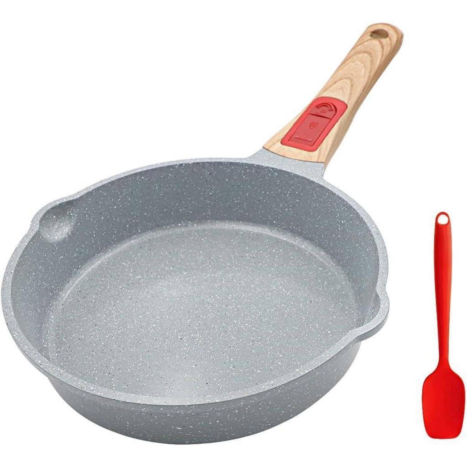 Eine graue Antihaft-Pfanne mit einem roten Holzgriff wird zusammen mit einem roten Pfannenwender präsentiert.