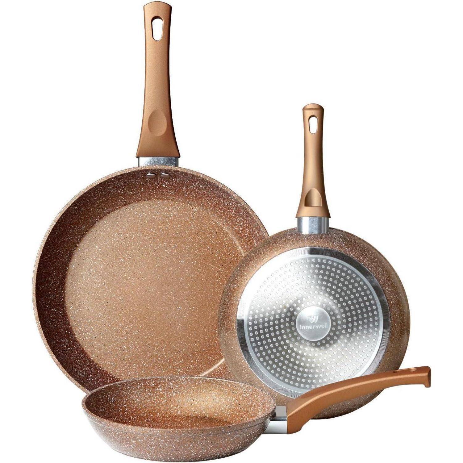 Drei Antihaft-Pfannen mit braunen Sprenkelflächen und ergonomischen Griffen, frontal und seitlich präsentiert.