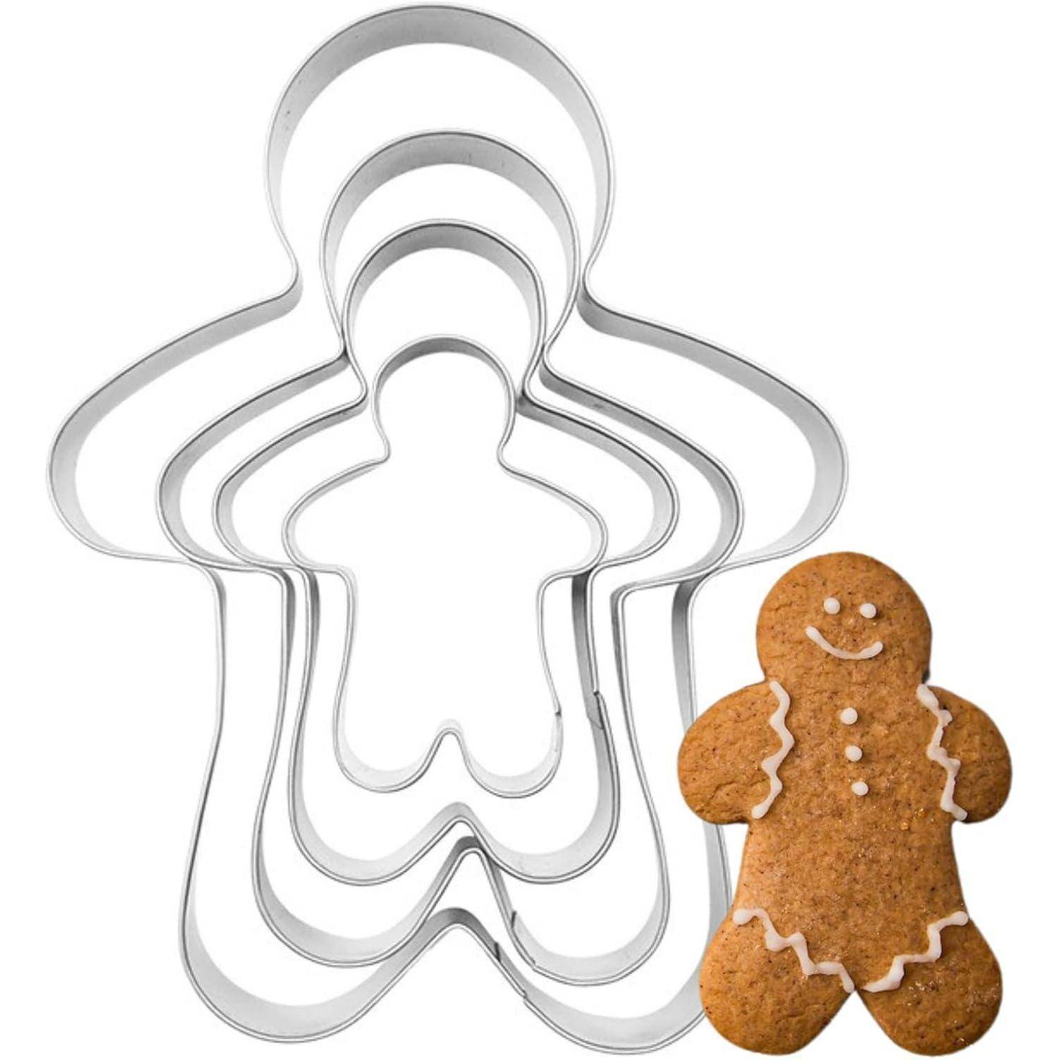 Fünf ineinander verschachtelte Ausstechformen für Lebkuchenmännchen neben einem verzierten Lebkuchenmann.