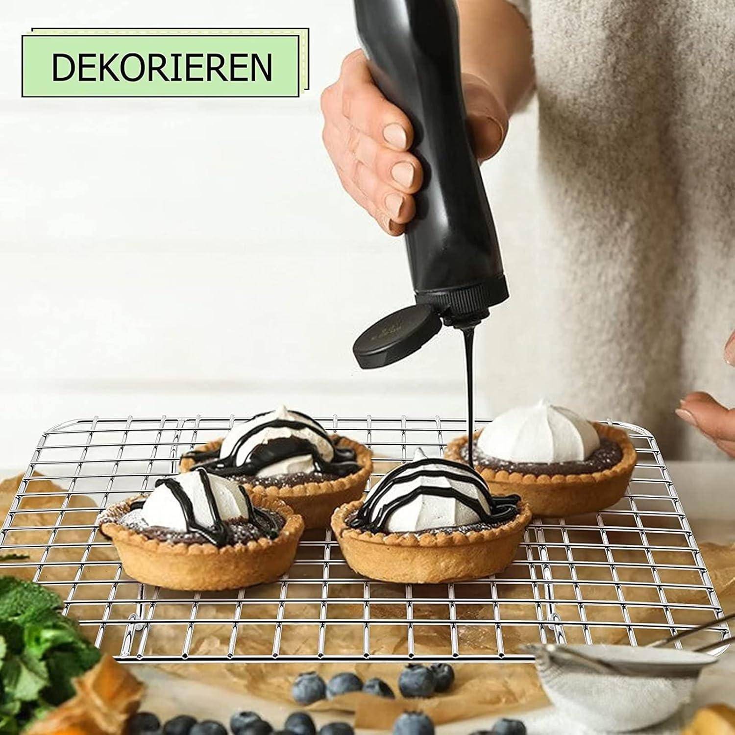 Eine Person dekoriert vier kleine Törtchen mit Schokoladensoße auf einem Kuchengitter. Das Wort 'DEKORIEREN' erscheint in der oberen linken Ecke.