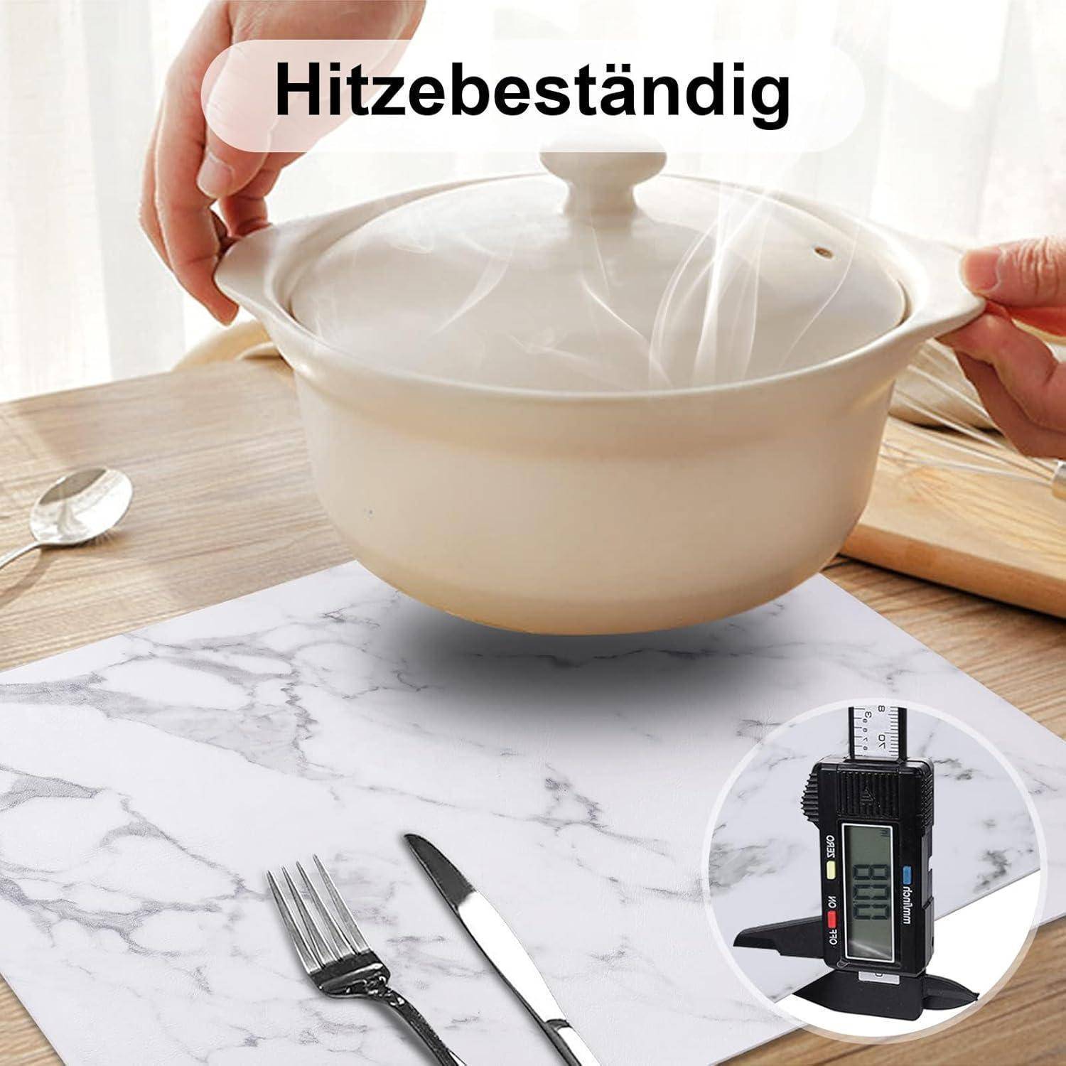 Hände, die einen dampfenden Topf über einem Marmorarbeitsplatten-Schutz halten. Einblendung zeigt ein Hitzeschutz-Messgerät mit der Anzeige '198,6 °F'.