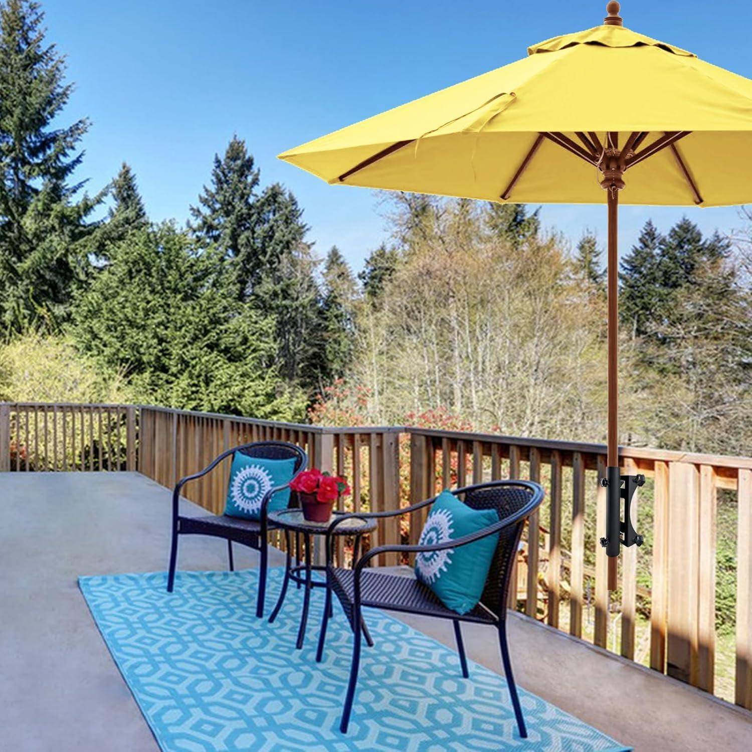 Outdoor-Terrasse mit blauem Teppich, zwei Korbstühlen und einem Tisch mit roten Blumen unter einem großen gelben Sonnenschirm, umgeben von Bäumen.