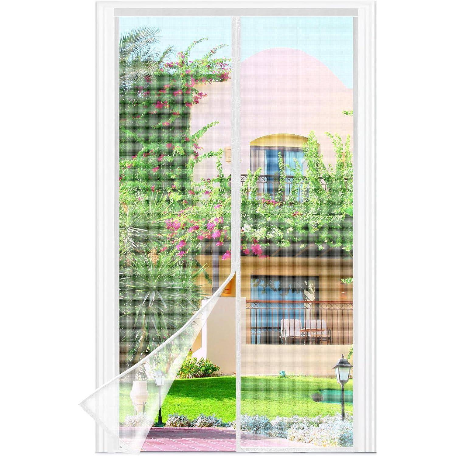 Ein malerischer Blick durch ein Fenster zeigt einen Garten mit blühenden Büschen und einen Teil eines Hauses mit einem Balkon, der eine ruhige Atmosphäre schafft.