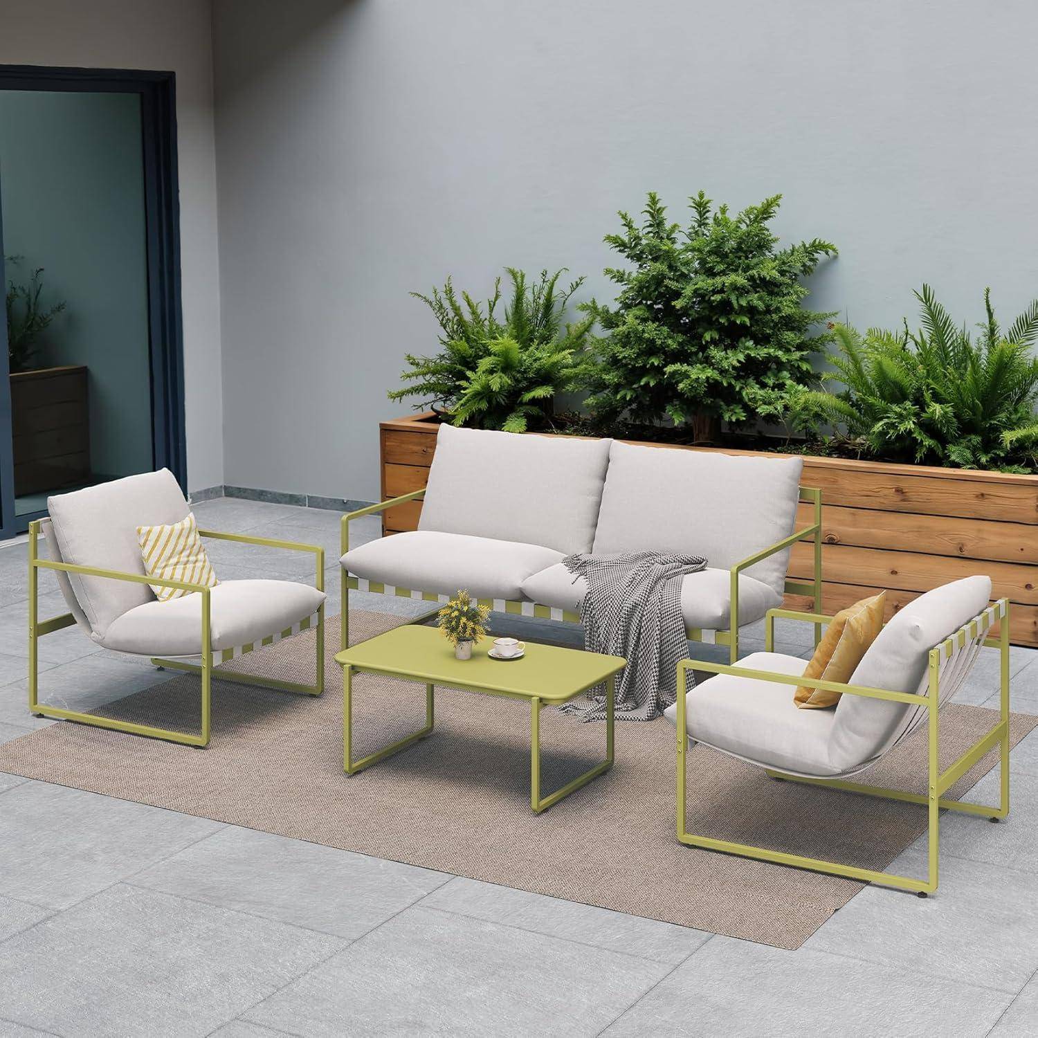 Eine Terrasse mit moderner Outdoor-Möbeln umfasst ein weißes gepolstertes Sofa, zwei Stühle und einen kleinen Tisch auf einem gefliesten Boden, umgeben von Topfpflanzen.