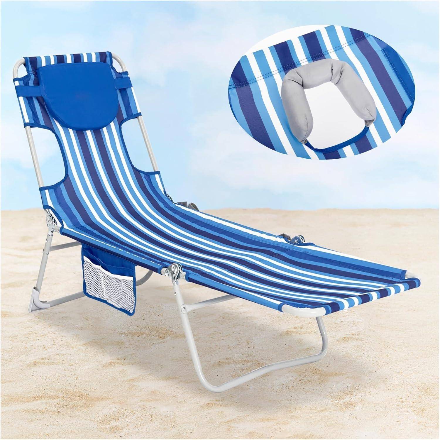 Ein blau-weiß gestreifter Strandliege-Stuhl mit angebrachter Kopfstütze und seitlichen Taschen steht auf sandigem Strand.