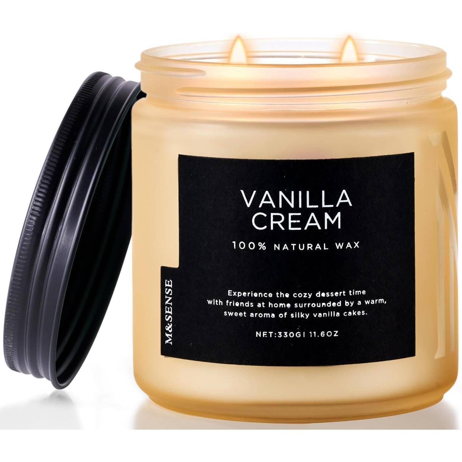 Eine Vanillecreme-duftende Kerze in einem Glasgefäß mit einem schwarzen Etikett. Der Deckel ist geöffnet und zeigt das 100% natürliche Wachs sowie den einladenden Duft.