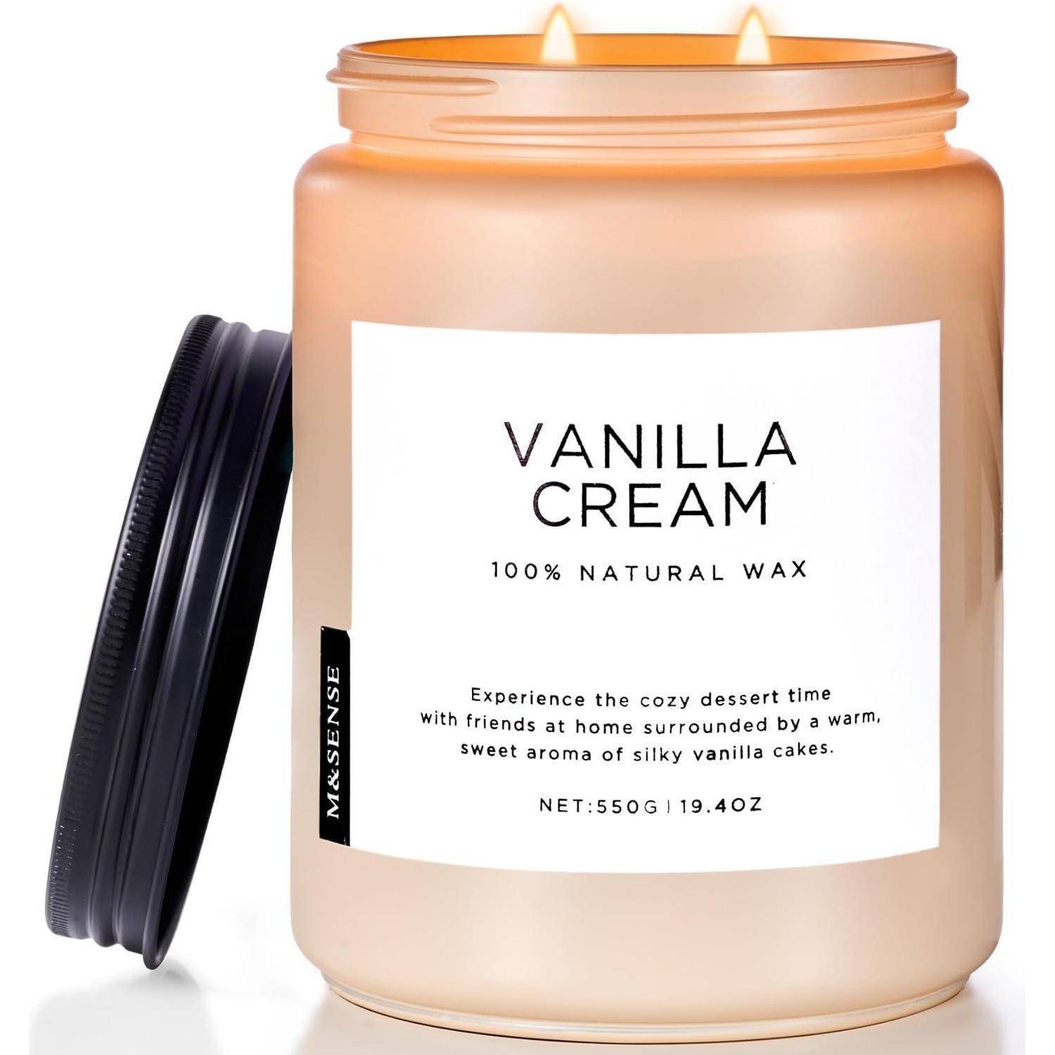 Eine angezündete Kerze mit der Aufschrift Vanilla Cream, 100% natürliches Wachs, in einem Glas mit einem schwarzen Deckel daneben; der Text beschreibt ein warmes, süßes Vanillearoma.