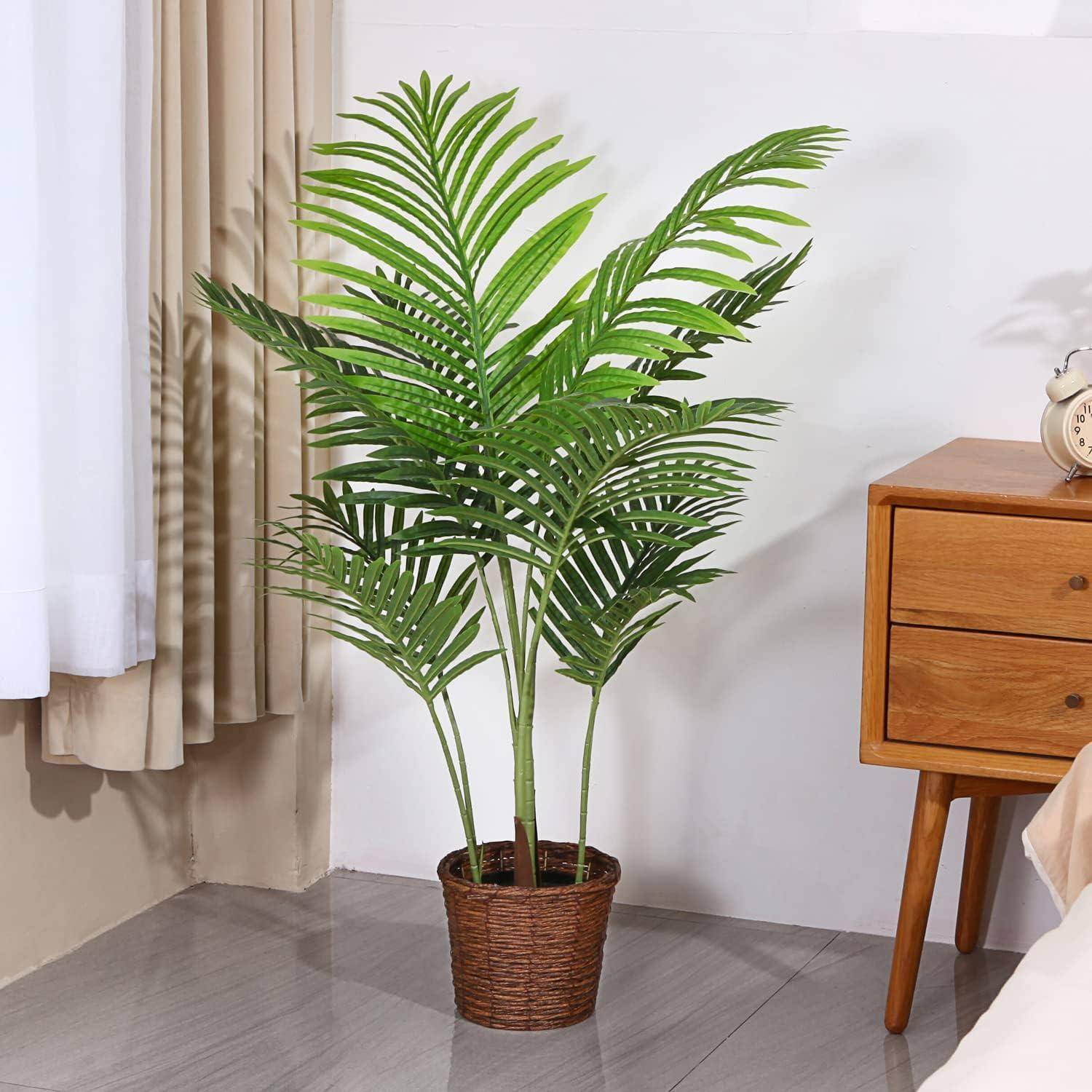 Eine Palme im Topf steht neben einem Holzseitentisch in einem hellen Raum mit gefliesten Böden und einem Vorhang, der entlang der Wand hängt.