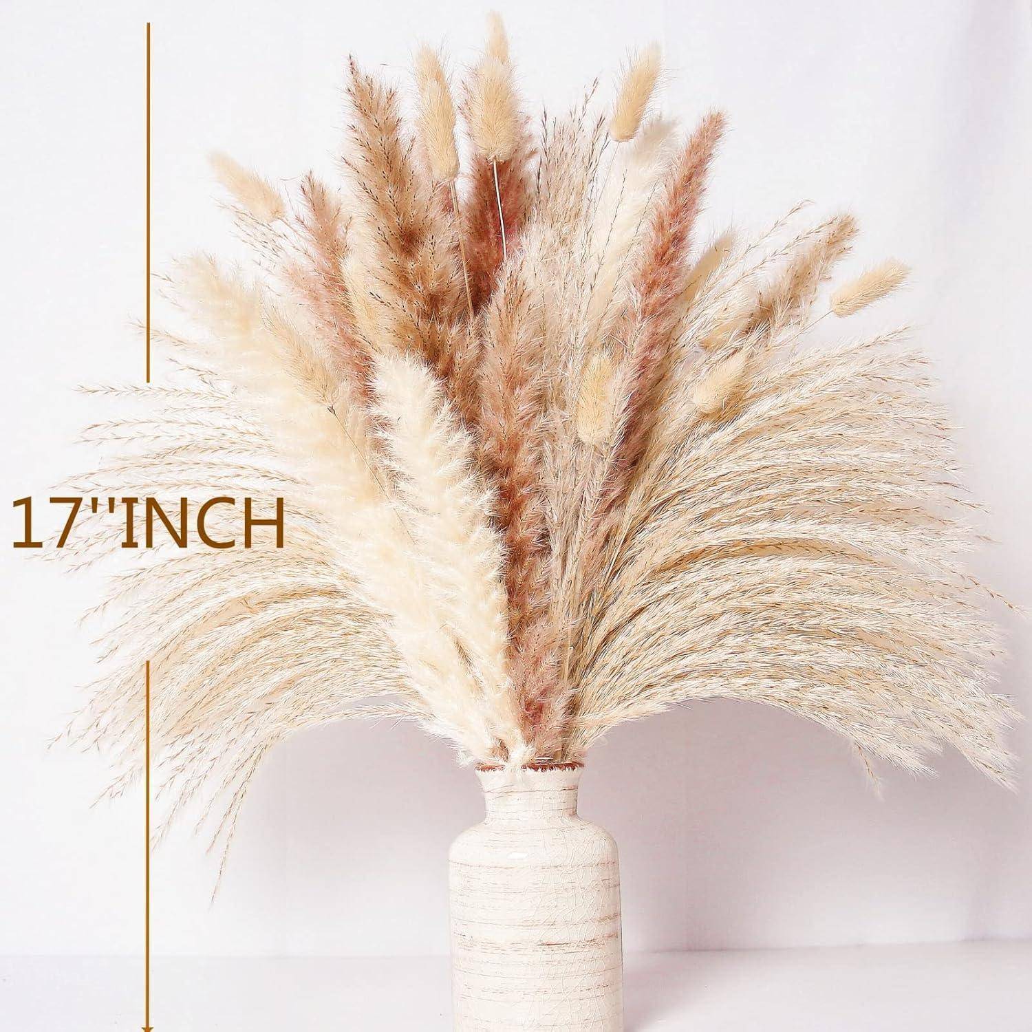Ein 17 Zoll hoher Blumenstrauß aus dekorativen Trockengrässern, einschließlich beige Pampasgras und anderen federartigen Pflanzen, in einer neutralen Keramikvase.