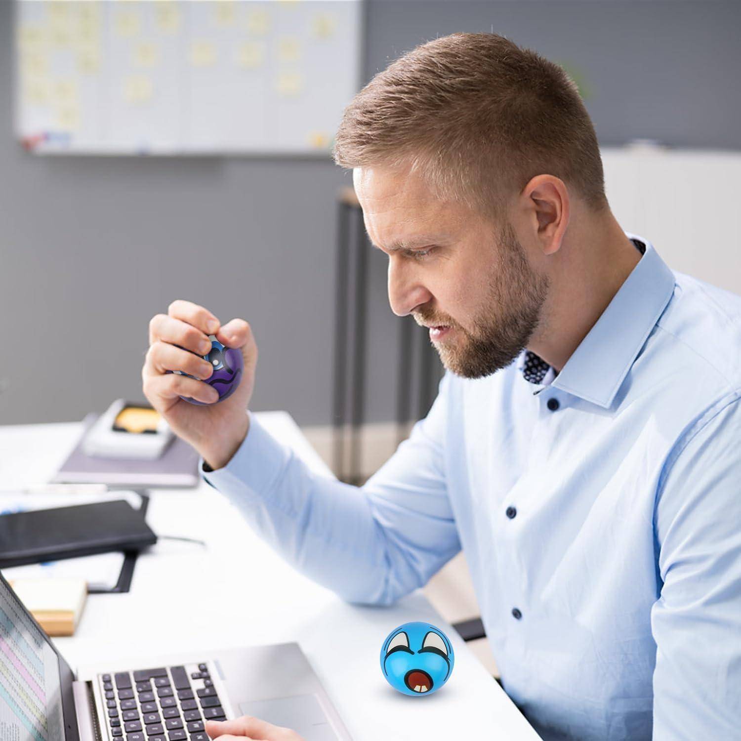 Eine Person sitzt an einem Schreibtisch, konzentriert auf einen Computer, während sie einen Stressball benutzt. Ein Stift, ein Notizbuch und ein Telefon liegen in der Nähe.
