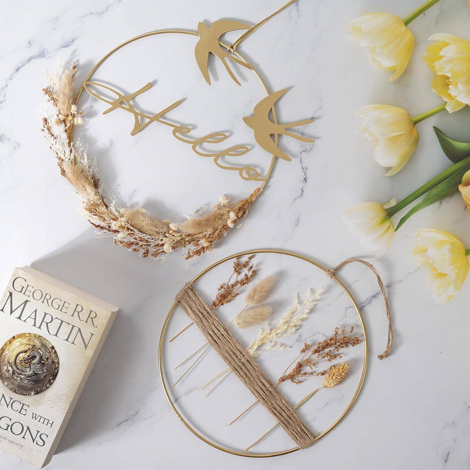 Eine dekorative Flat-Lay-Komposition mit gelben Tulpen, einem Buch von George R.R. Martin und goldenen Wandbehängen mit getrockneten Blumen und dem Wort 