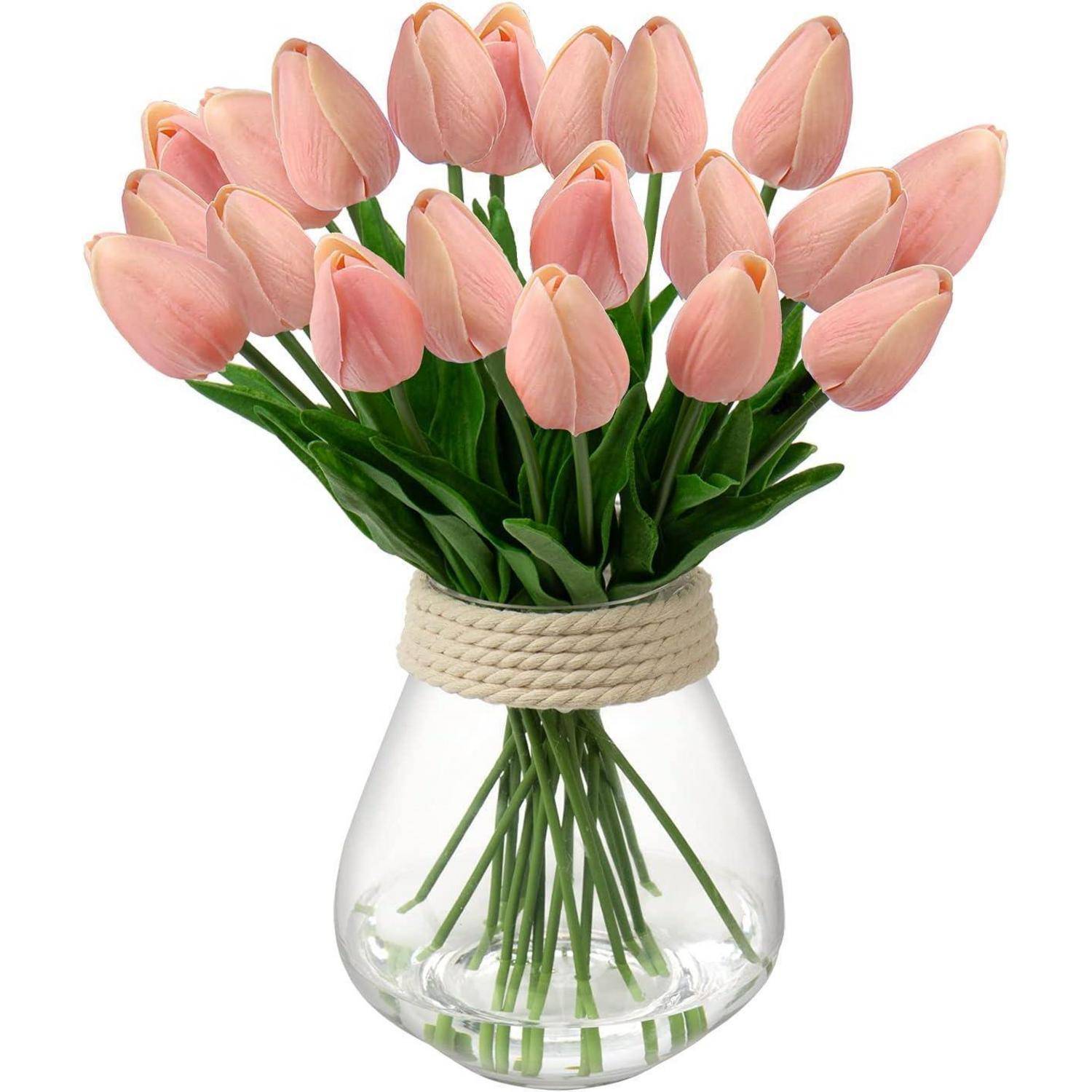 Eine klare Vase mit einem Seilakzent enthält einen Strauß rosa Tulpen mit grünen Stängeln, der ordentlich und symmetrisch angeordnet ist.