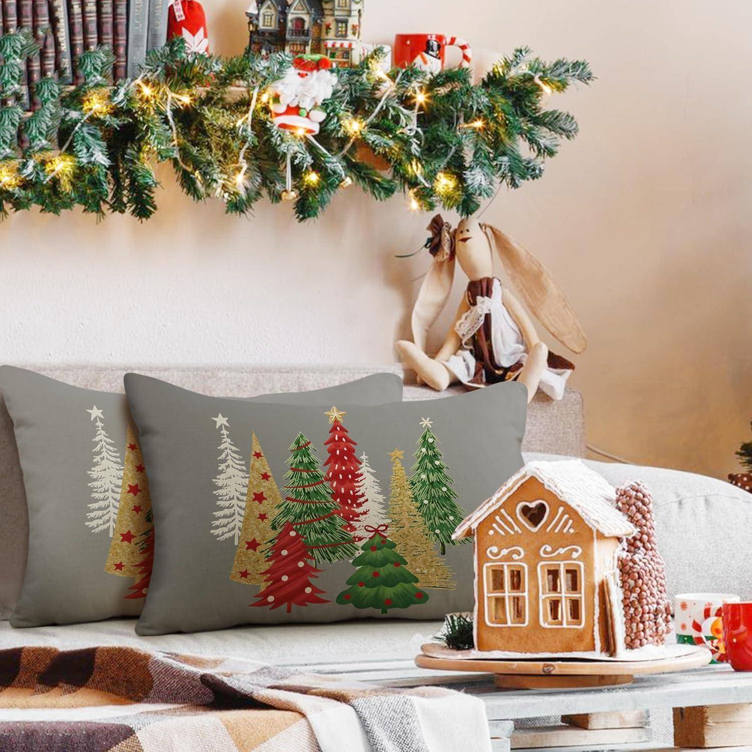 Ein gemütliches Wohnzimmer, weihnachtlich geschmückt mit einem Lebkuchenhaus und kissen mit Baummustern auf der Couch, Girlanden und Lichtern darüber.
