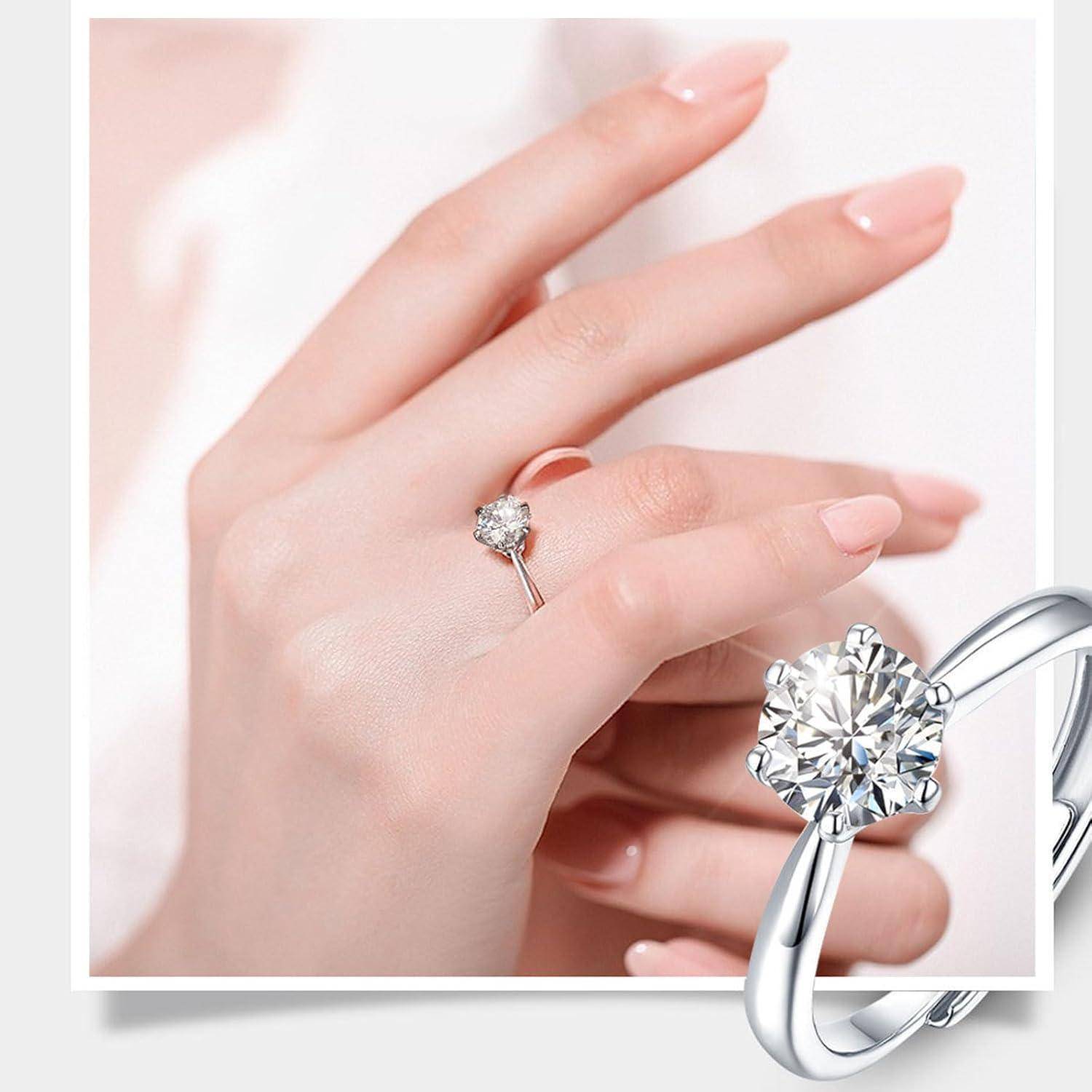 Eine Frauenhand mit einem Solitär-Diamantring am Ringfinger. Der Diamant ist groß und rund, gefasst in einem schlichten, eleganten Ring.