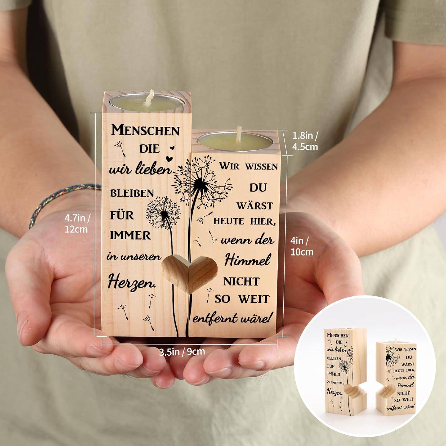 Eine Person hält Kerzenhalter aus Holz, die mit deutschem Text über Liebe und Erinnerung graviert sind und eine Herzform sowie dekorative Details aufweisen.