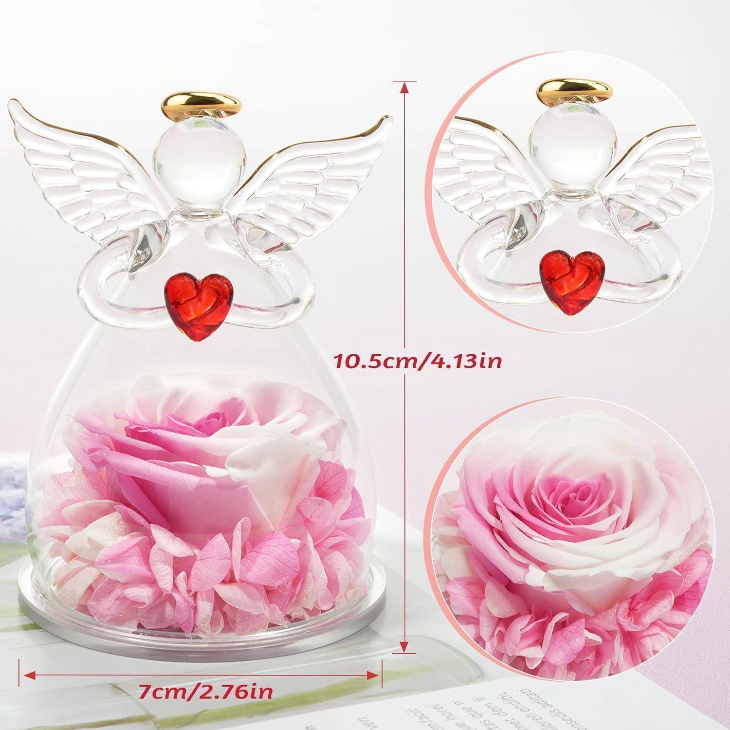 Glasengelfigur mit goldenem Heiligenschein und Flügeln, einen roten Herzen haltend. Innen ruht eine rosa Rose auf Rosenblütenblättern. Abmessungen: 10,5 cm Höhe, 7 cm Breite.