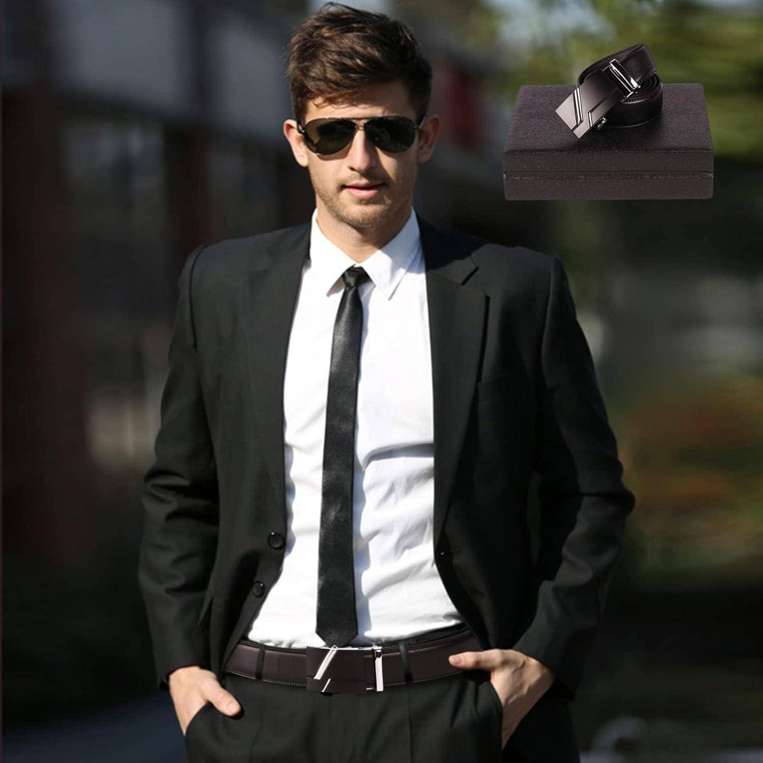 Ein Mann in einem schwarzen Anzug und Krawatte, mit Sonnenbrille, steht selbstbewusst im Freien. Eingefügtes Bild eines schwarzen Ledergürtels mit silberner Schnalle.