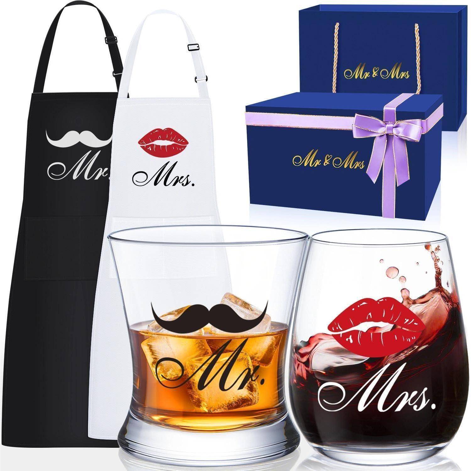 Set für Ihn und Sie mit Schürzen und Gläsern, die 'Herr' mit einem Schnurrbart und 'Frau' mit Lippen zeigen, in einer Geschenkbox.