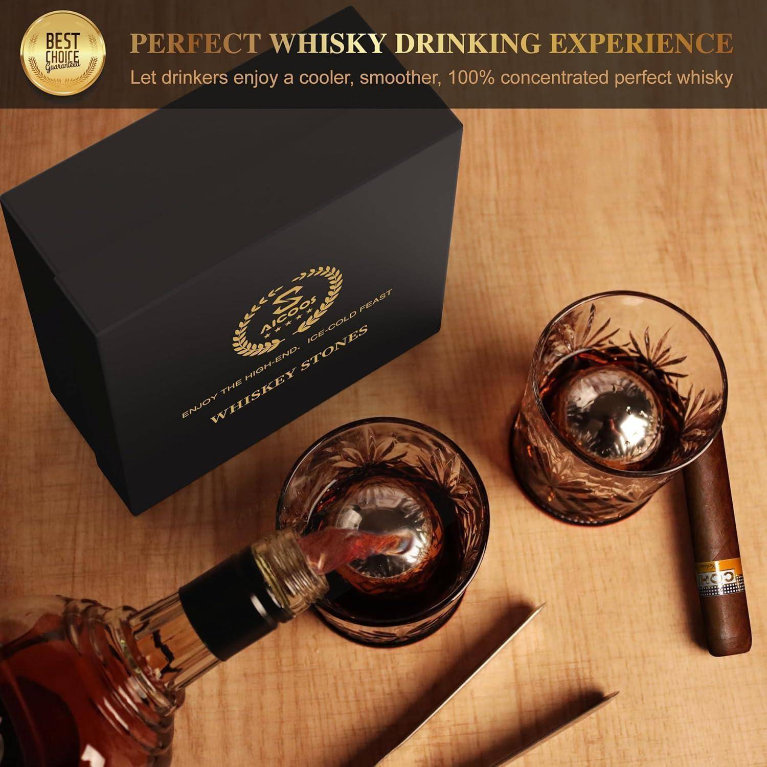 Schachtel mit 'Whisky-Steinen', zwei Gläser mit Whiskey und Steinen, eine eingeschenkte Whiskyflasche und eine Zigarre auf einem Tisch. Banner liest: 'Perfektes Whisky-Trinkerlebnis'.