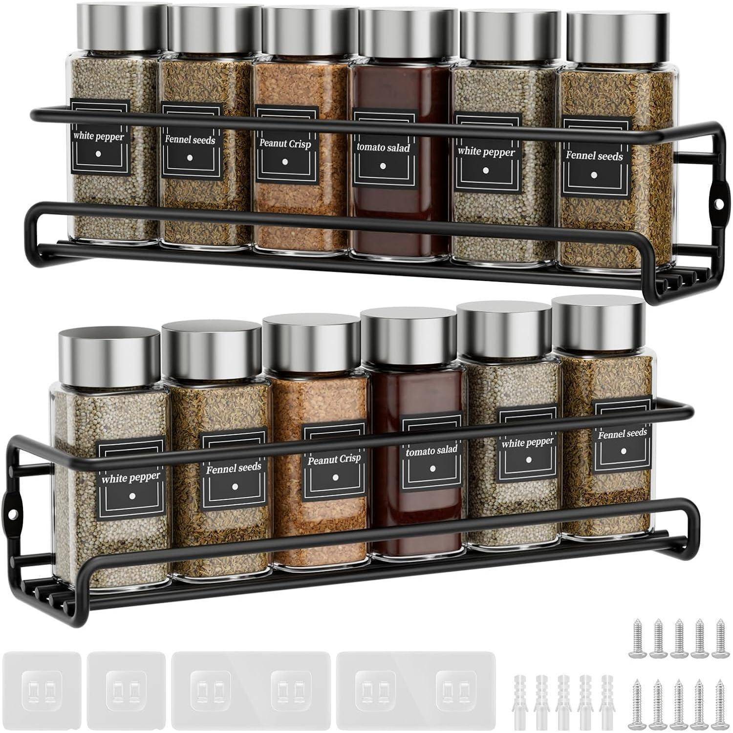 Zwei schwarze Gewürzregale an der Wand befestigt, die jeweils sechs Glasgefäße mit Metalldeckeln tragen, die verschiedene Gewürze enthalten und mit 'weißem Pfeffer', 'Fenchelsamen', 'Erdnusskruste' und 'Tomatensalat' beschriftet sind. Schrauben und Dübel sind darunter enthalten.
