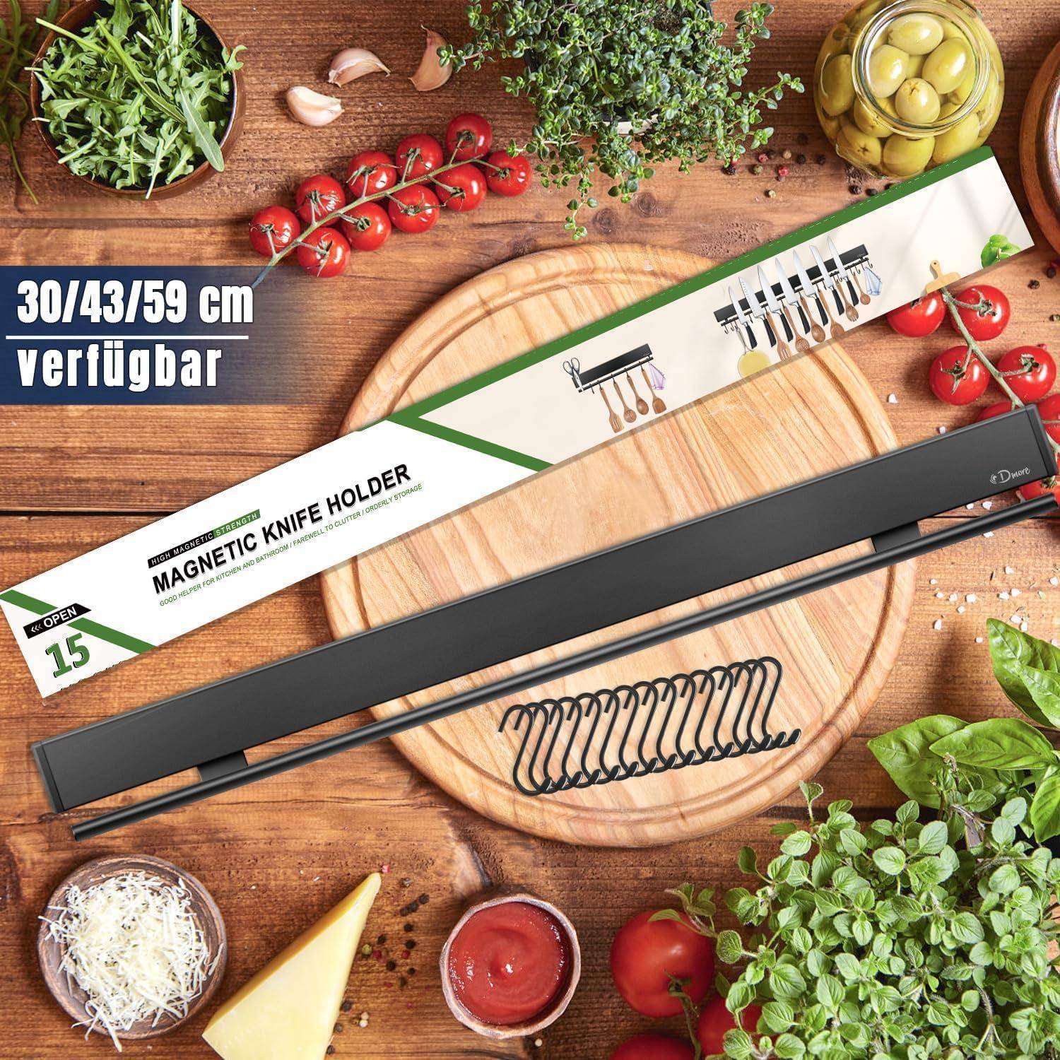 Magnetischer Messerhalter auf einer Holzarbeitsplatte in der Küche, umgeben von frischen Zutaten wie Tomaten, Paprika und Kräutern. Text lautet '30/43/59 cm verfügbar'.