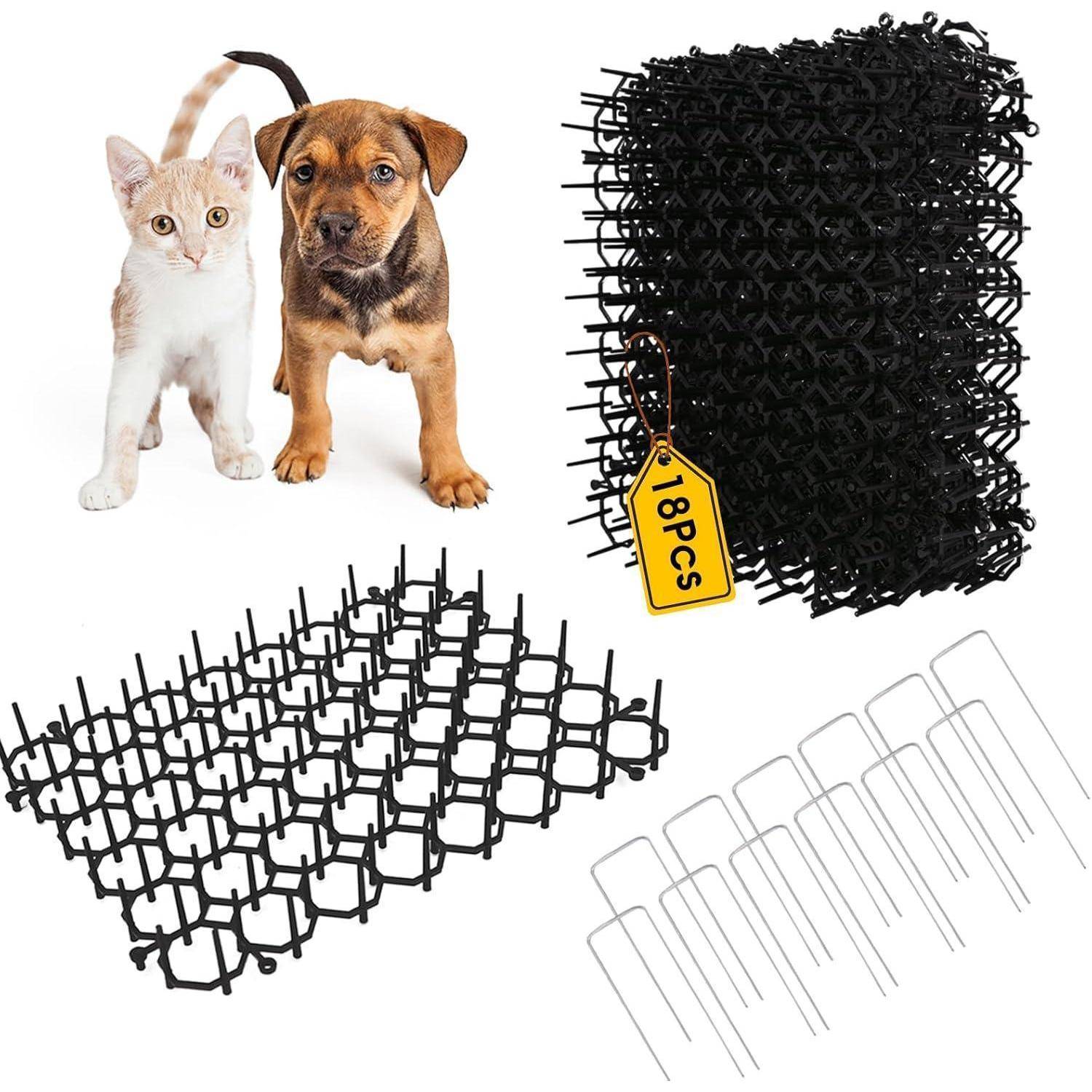 Katze und Hund posieren zusammen. In der Nähe ein schwarzes Mattenteils, mit der Aufschrift '18PCS', mit U-förmigen Klammern, was auf eine Tierabsperrung oder ein Gartenmattensystem hindeutet.
