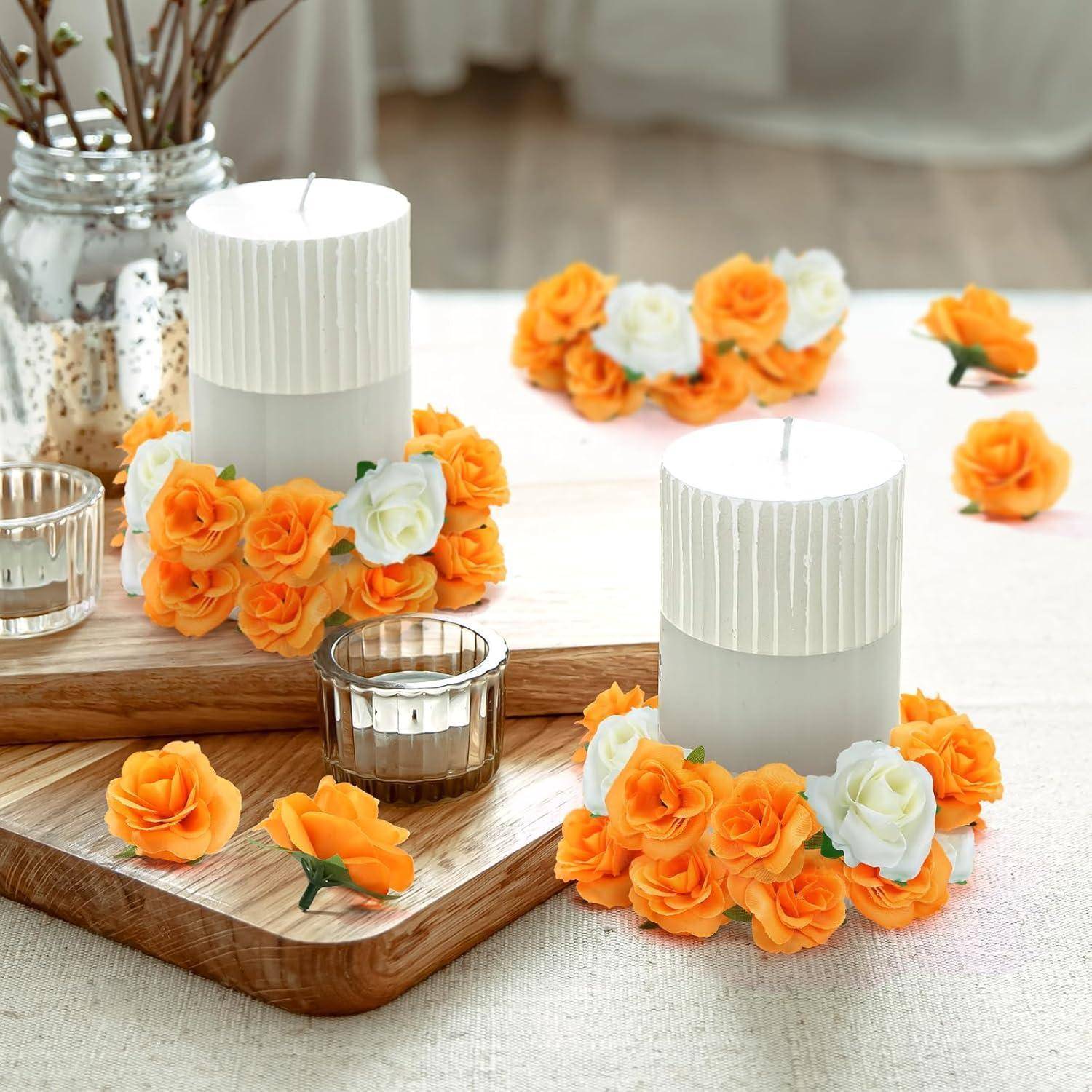 Ein Tisch, geschmückt mit weißen Kerzen, die mit orangen und weißen Blumen verziert sind. Vasen mit kahlen Zweigen und kleinen Blüten akzentuieren ebenfalls die Szene.