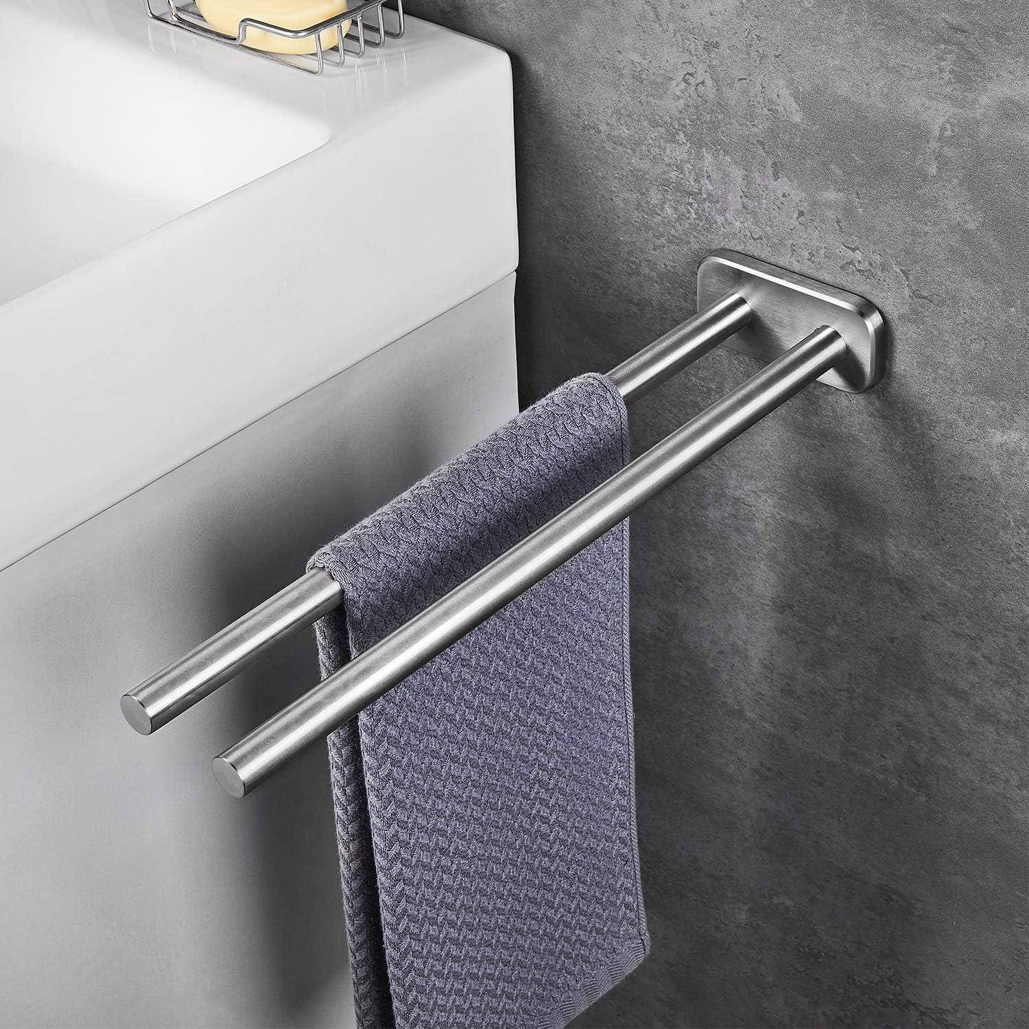 Ein hellviolettes Handtuch hängt an einer modernen, metallischen Handtuchstange, die an einer grauen Wand neben einem weißen Waschbecken befestigt ist.