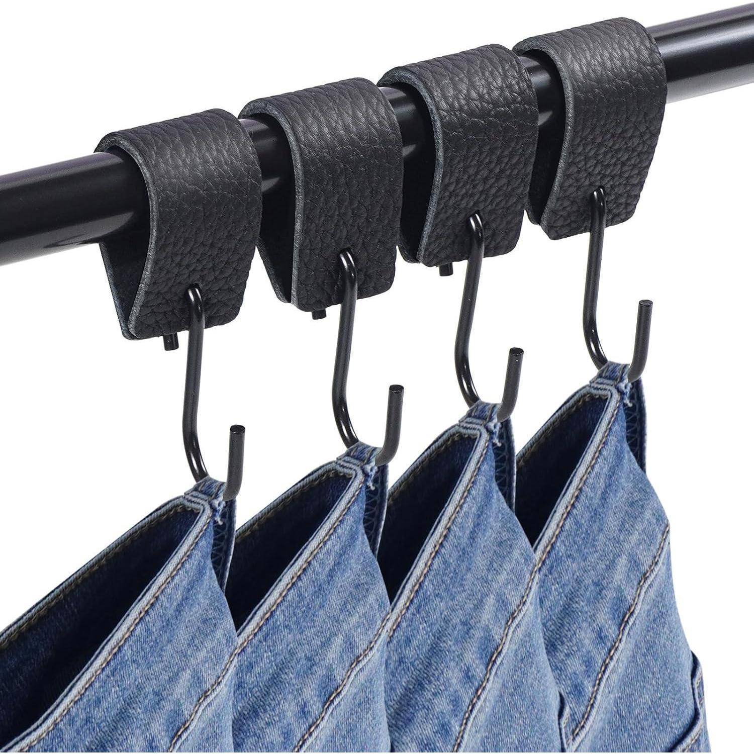 Jeans-Röcke, die an einer schwarzen Stange mit schwarzen Lederhaken aufgehängt sind, in einer ordentlichen Reihe ausgestellt.